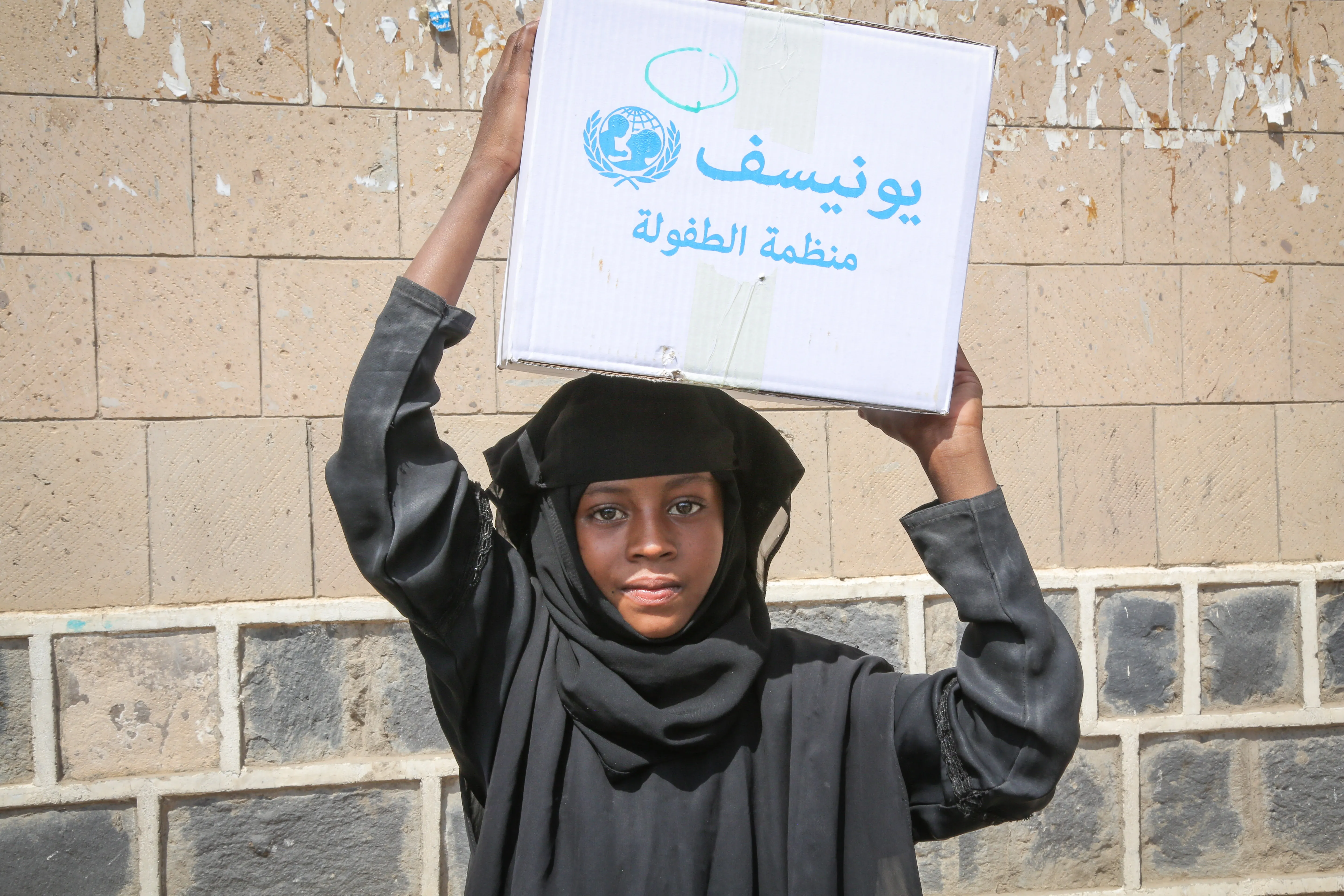 After being displaced by ongoing insecurity a young girl helps her family carry home a basic hygiene kit. They received urgent support through the Rapid Response Mechanism in Shuab