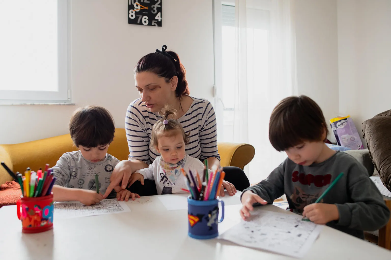 A mother in Macedonia helps her children study at home.
