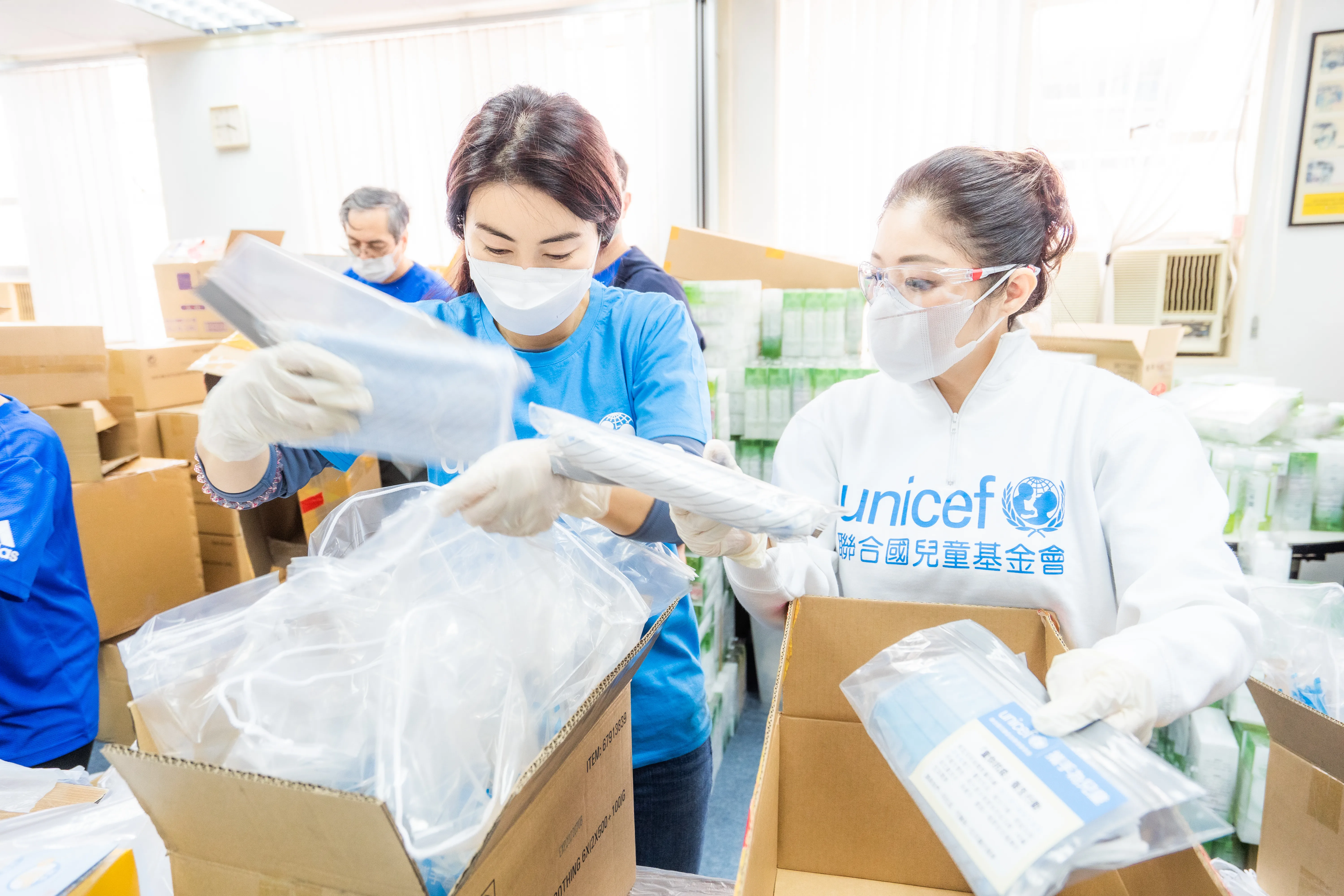 UNICEF workers unpacking with face masks on