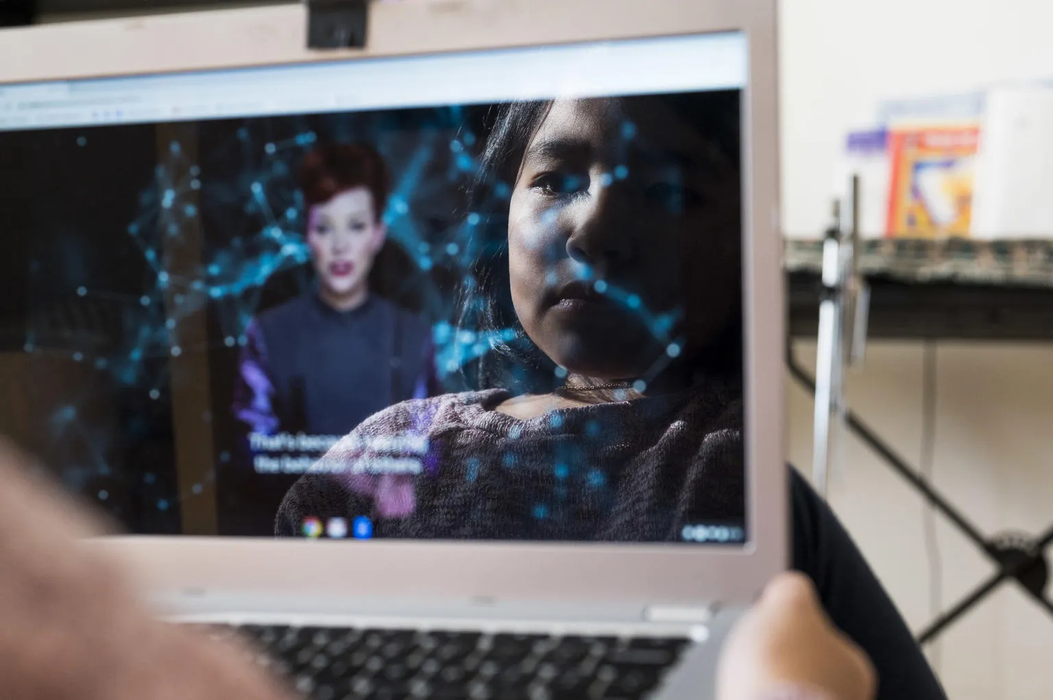 A child's face is reflected in a tablet screen.