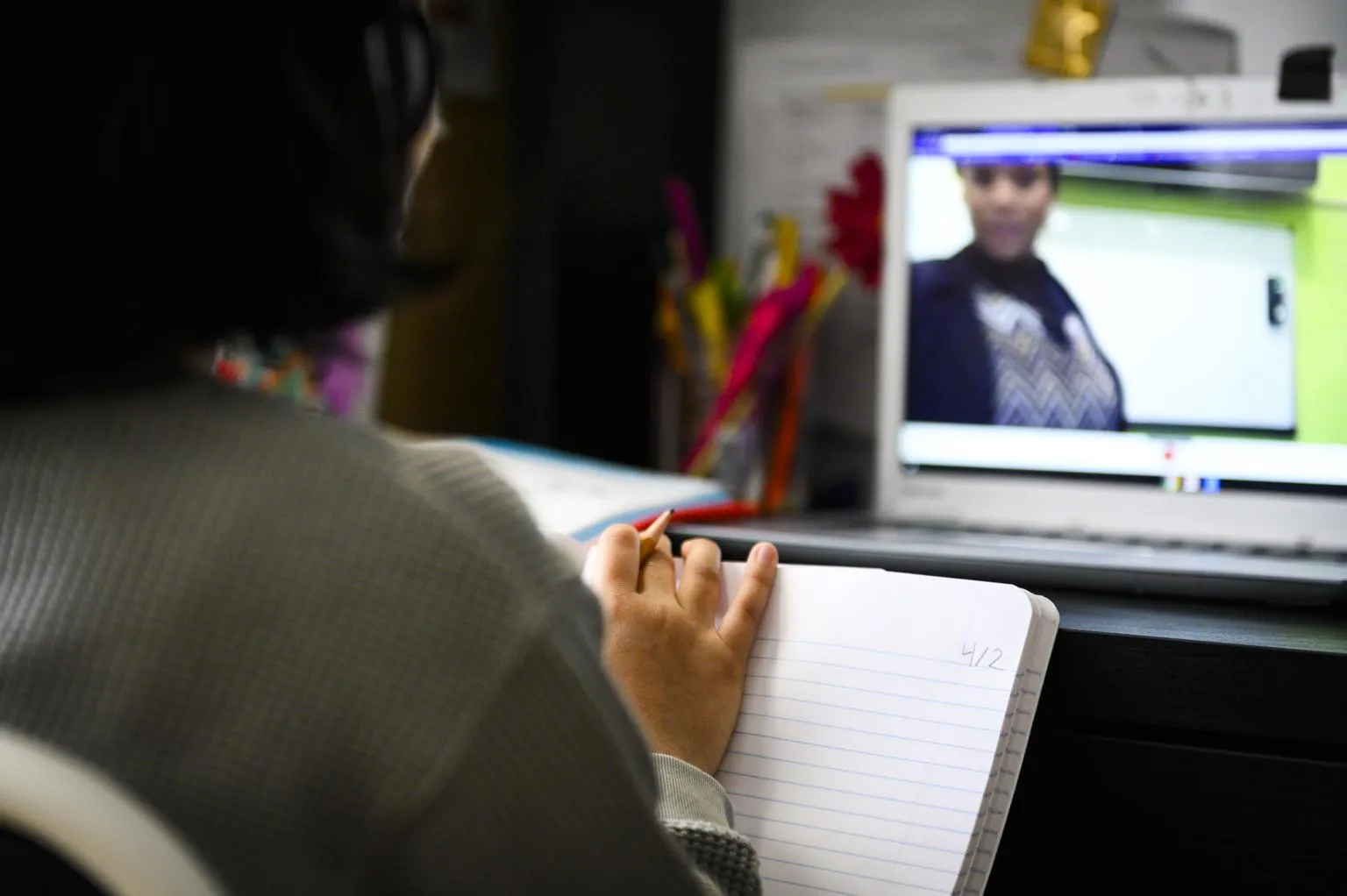 A student watches an lecture through their computer.