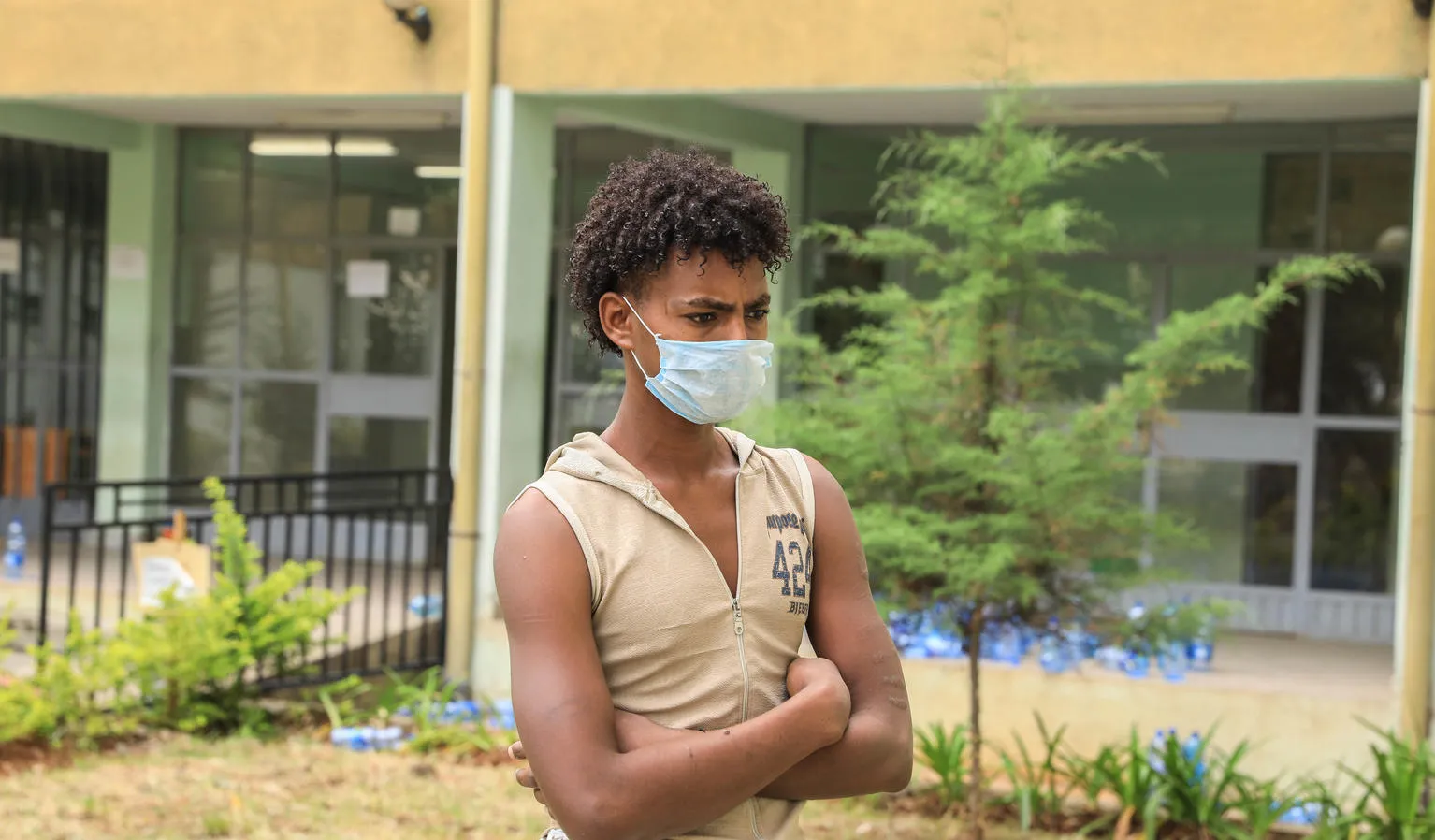 A young man stands outside a shelter for trafficked youth.