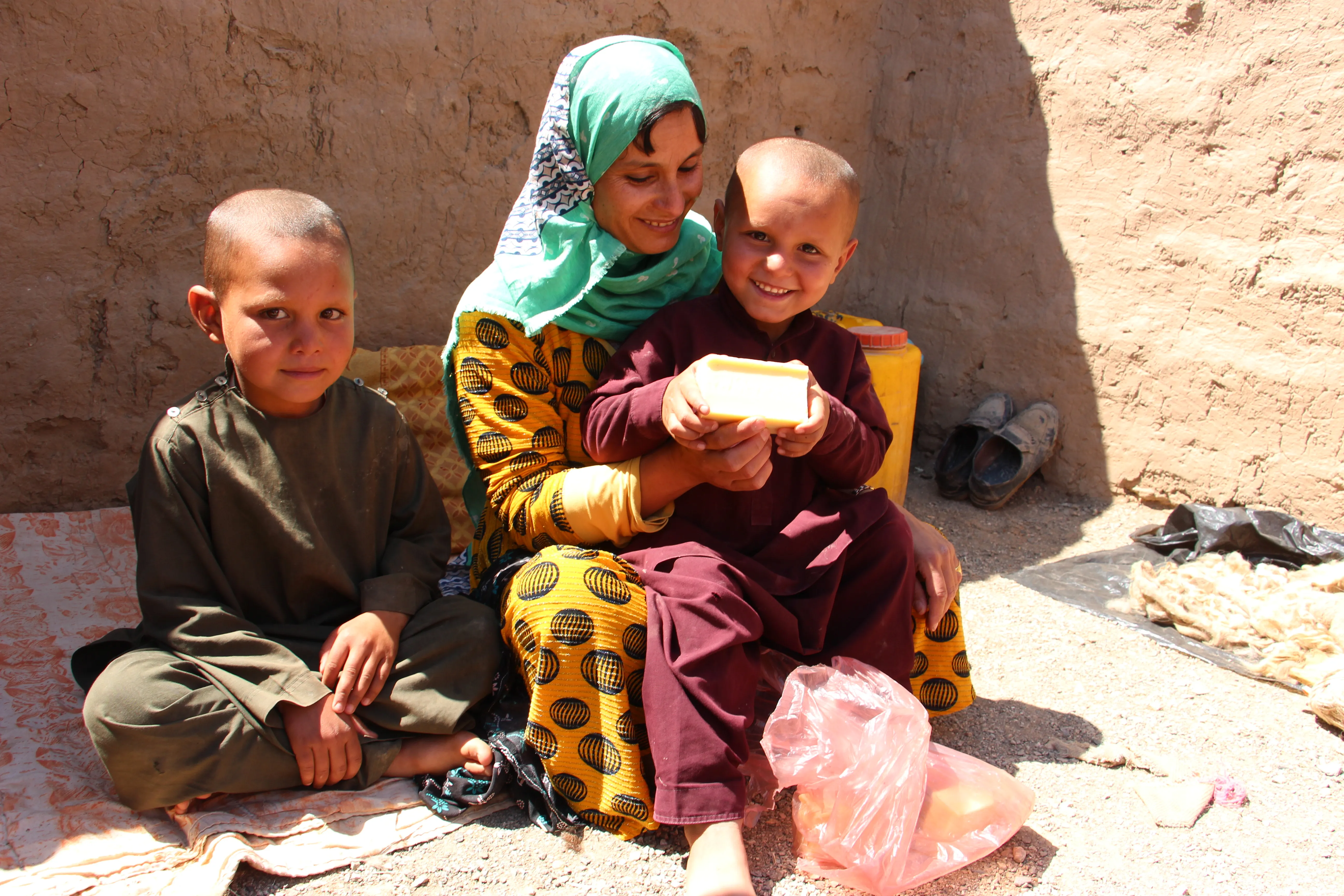 The picture shows a family who has received soap distribution in Herat IDP sites