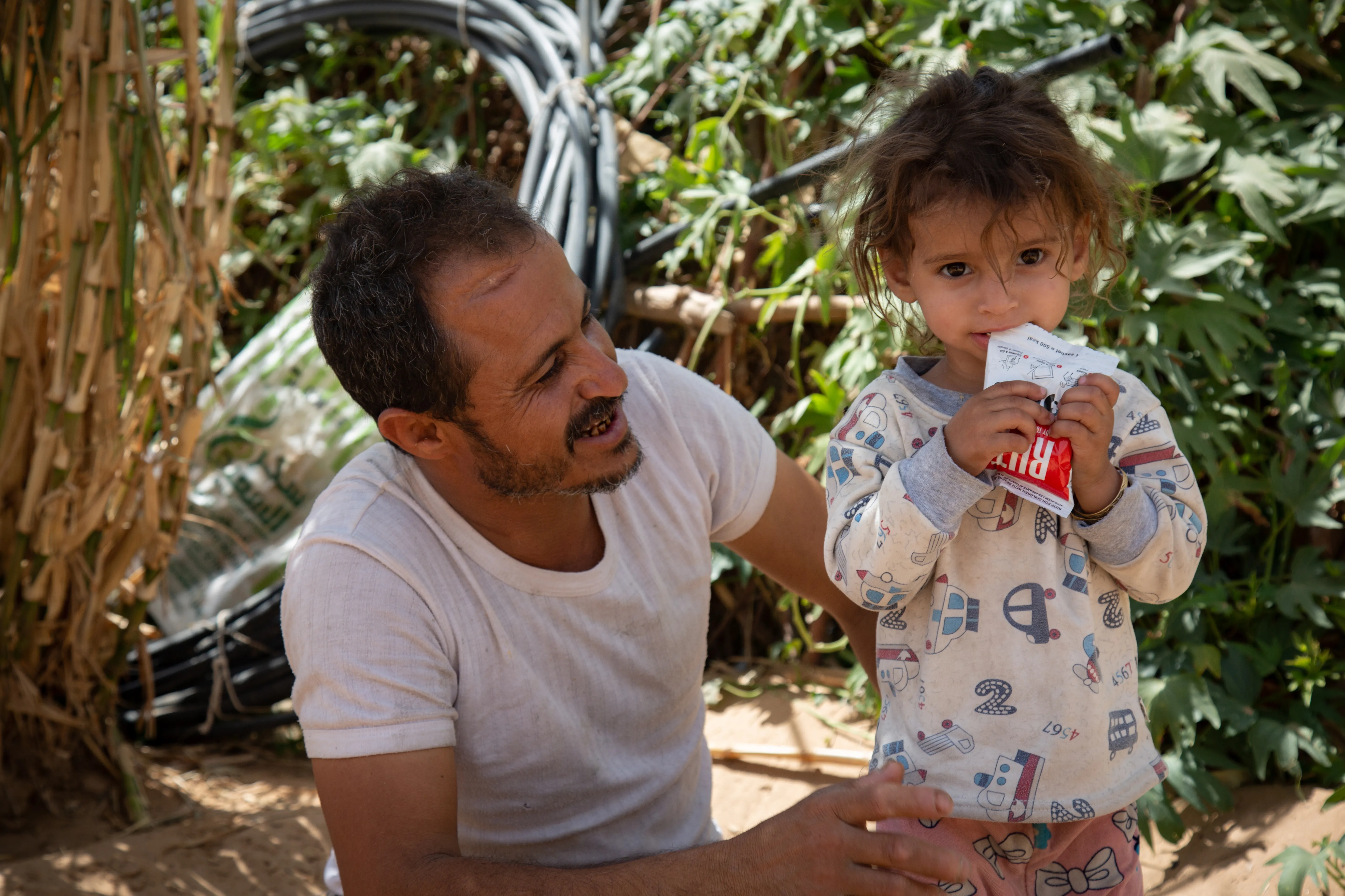 Moharram Al-Oshari, 35 years old, next to his 2 years and a half daughter, says "Before being displaced, I worked as a carpenter and we had a simple life"Mohammed Moharram Sa'ad Al-Oshari lives with his family in a camp for the displaced people in Ahl Al-Jalal in Mareb. Heis fled fighting with his family initially to Al Jawf and then, after Al Jawf was attacked, to Mareb. Although he receives a World Food Programme (WFP) food basket for his family, it is not enough.