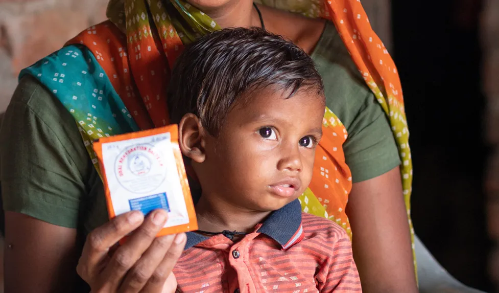 Pendant le confinement engendré par la crise de la COVID-19, une infirmière et un travailleur Anganwadi donnent à Sahil, 20 mois, et Gitaben, des sels de réhydratation orale et du zinc. 