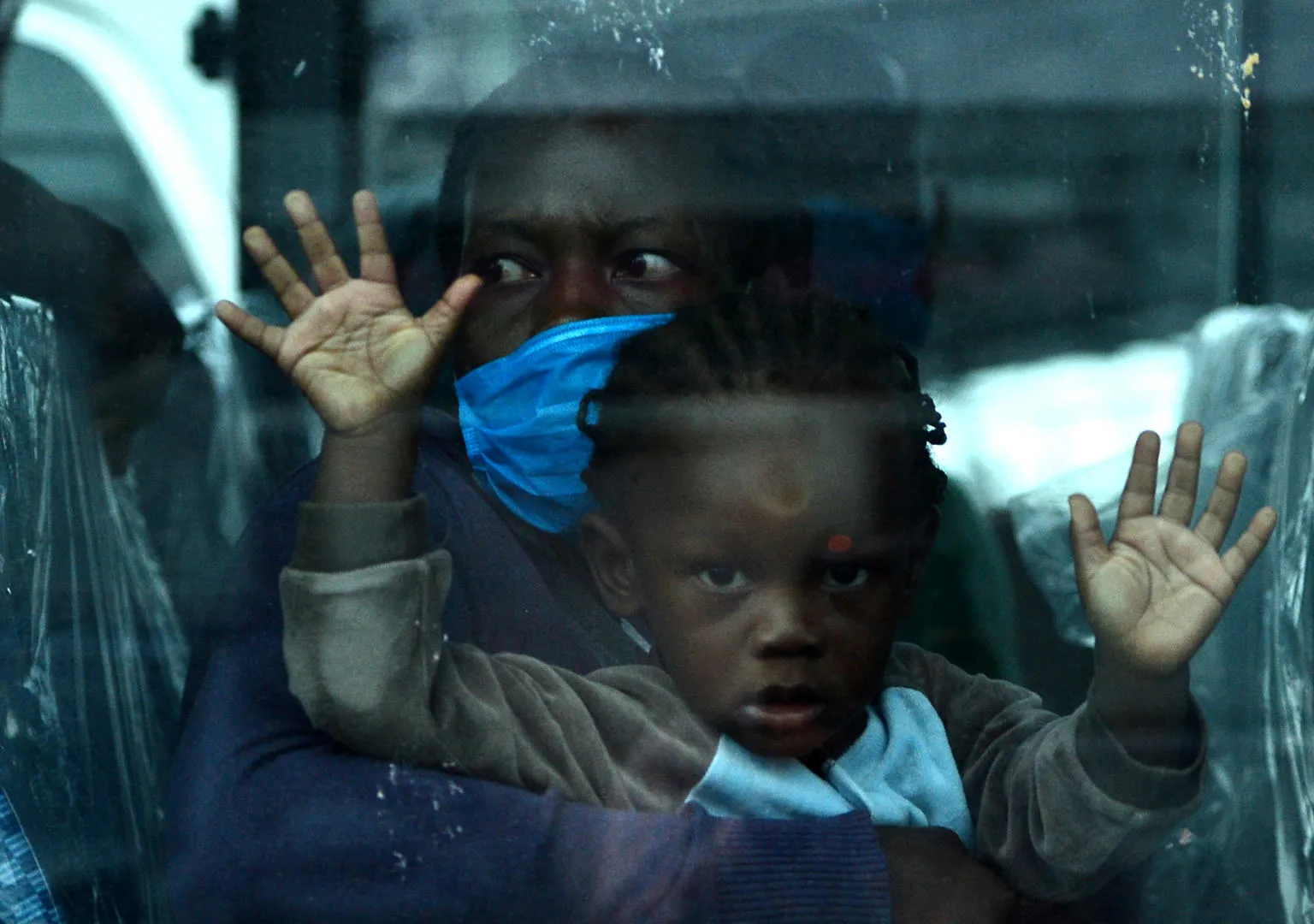 A mother and child are seen onboard a bus as they wait to be taken into quarantine.