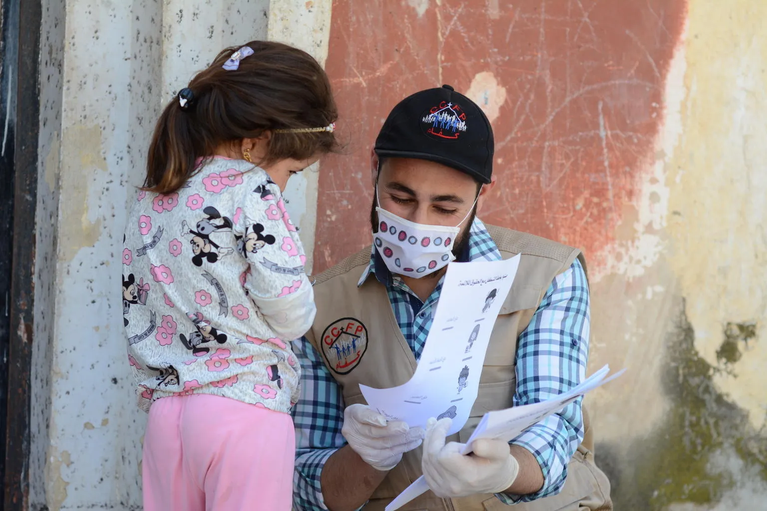 A UNICEF volunteer meets with a child in Syria.