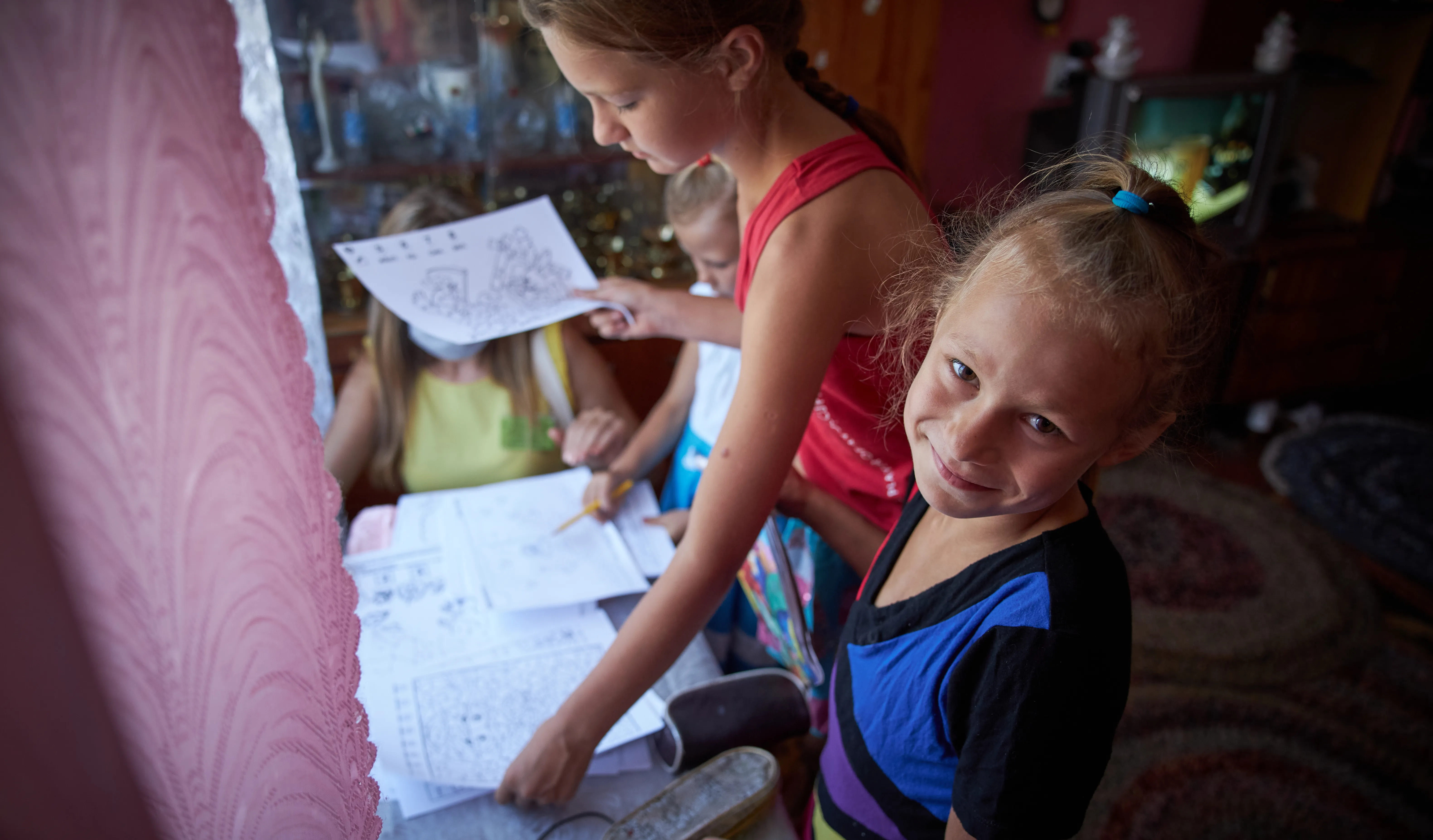 On 6 August 2020, sisters receive educational materials, including colouring books and exercise books, during a visit of a social worker and psychologist to their home in in Bilokurakyne, Eastern Ukraine.