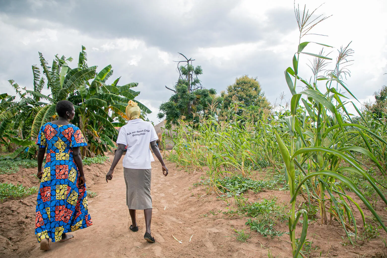 Harriet, a member of the Kilameling Parenting Without Violence group and chats with a para social worker from Save the Children in Kilameling ward, Obongi Town Council, Obongi District.