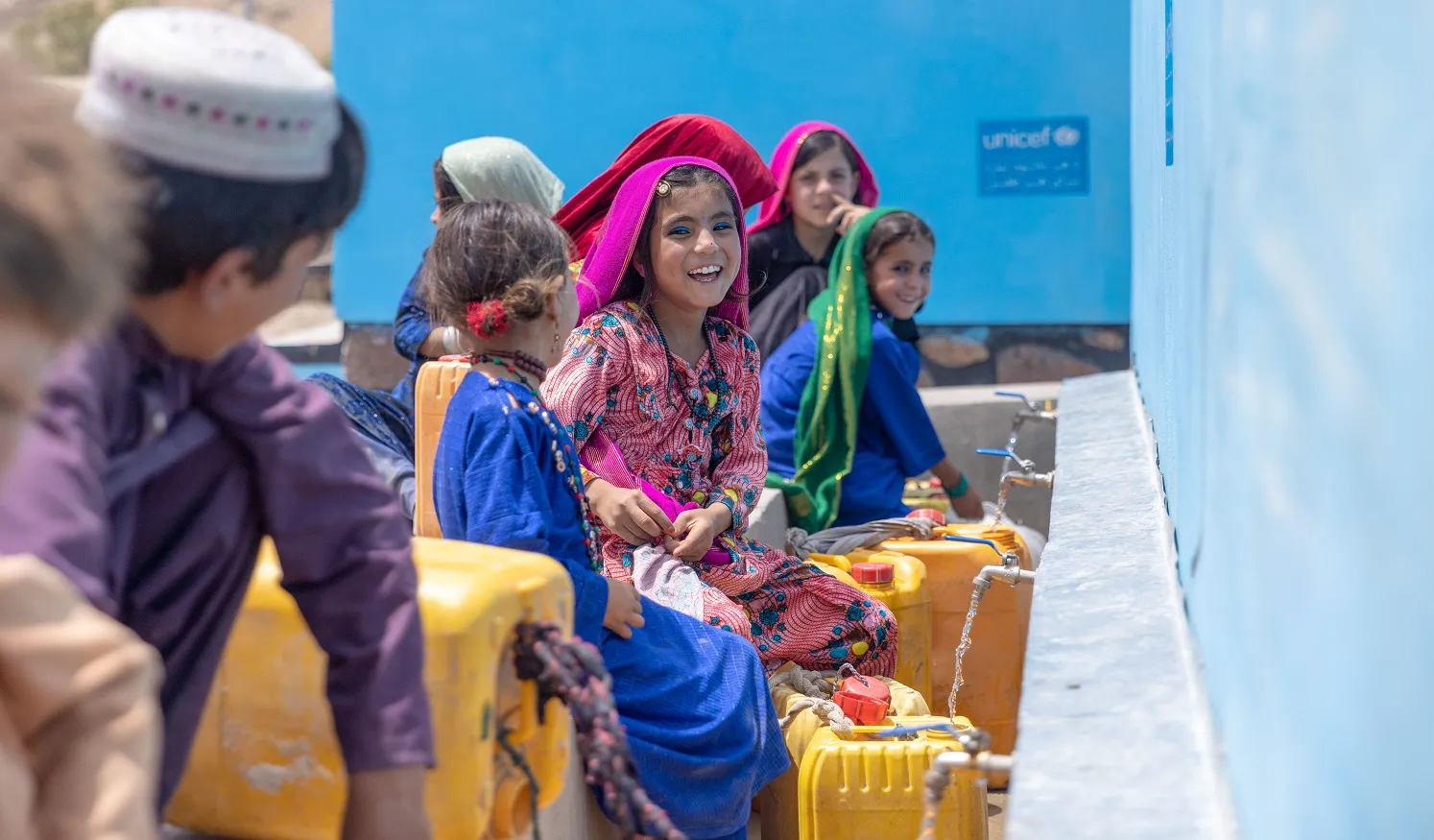 Children collect water from a UNICEF-supported tap in Badghis Province, Afghanistan.
