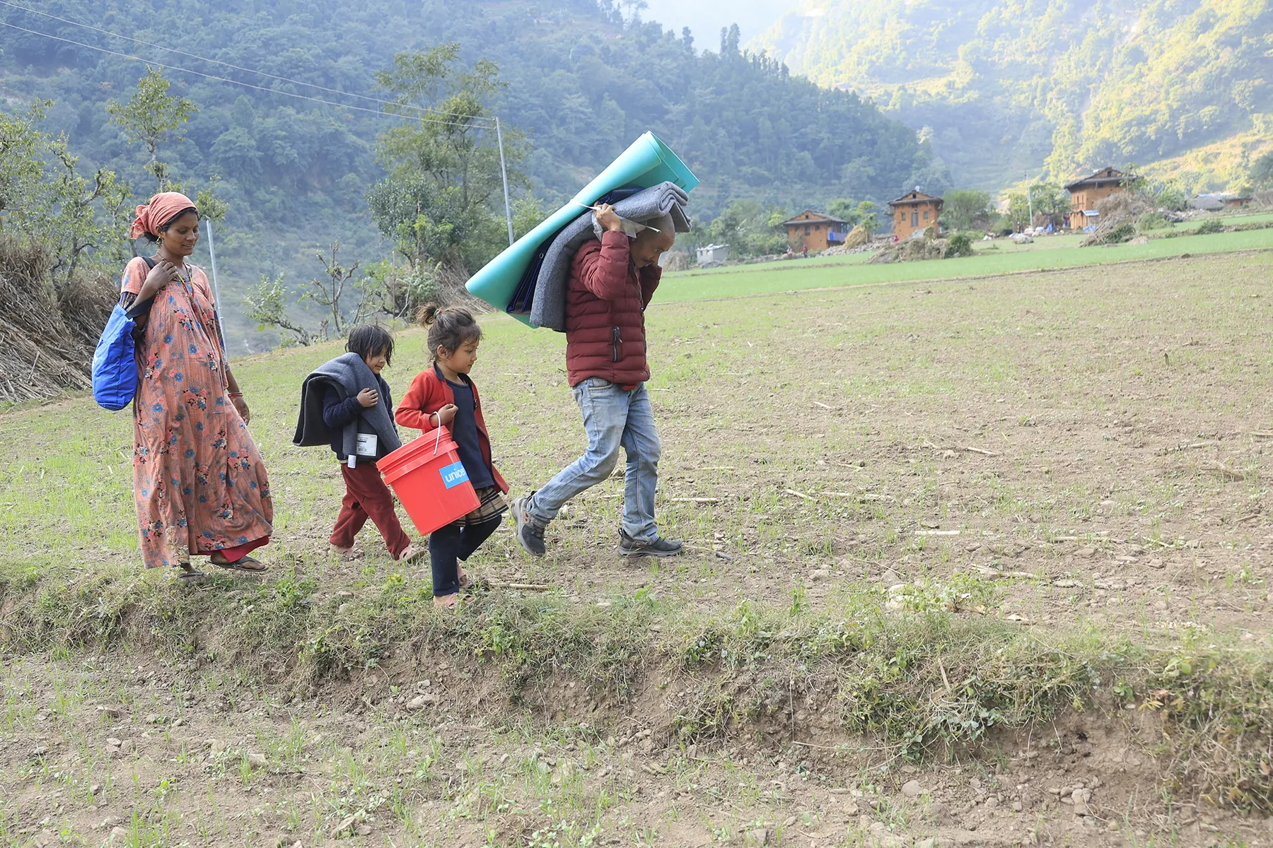 On 6 November 2023, in Aathbiskot Municipality in Rukum West District – in one of the communities most affected by the 6.4 magnitude quake that hit western Nepal on 3 November – a family of four receive relief supplies distributed by UNICEF in coordination with local authorities.