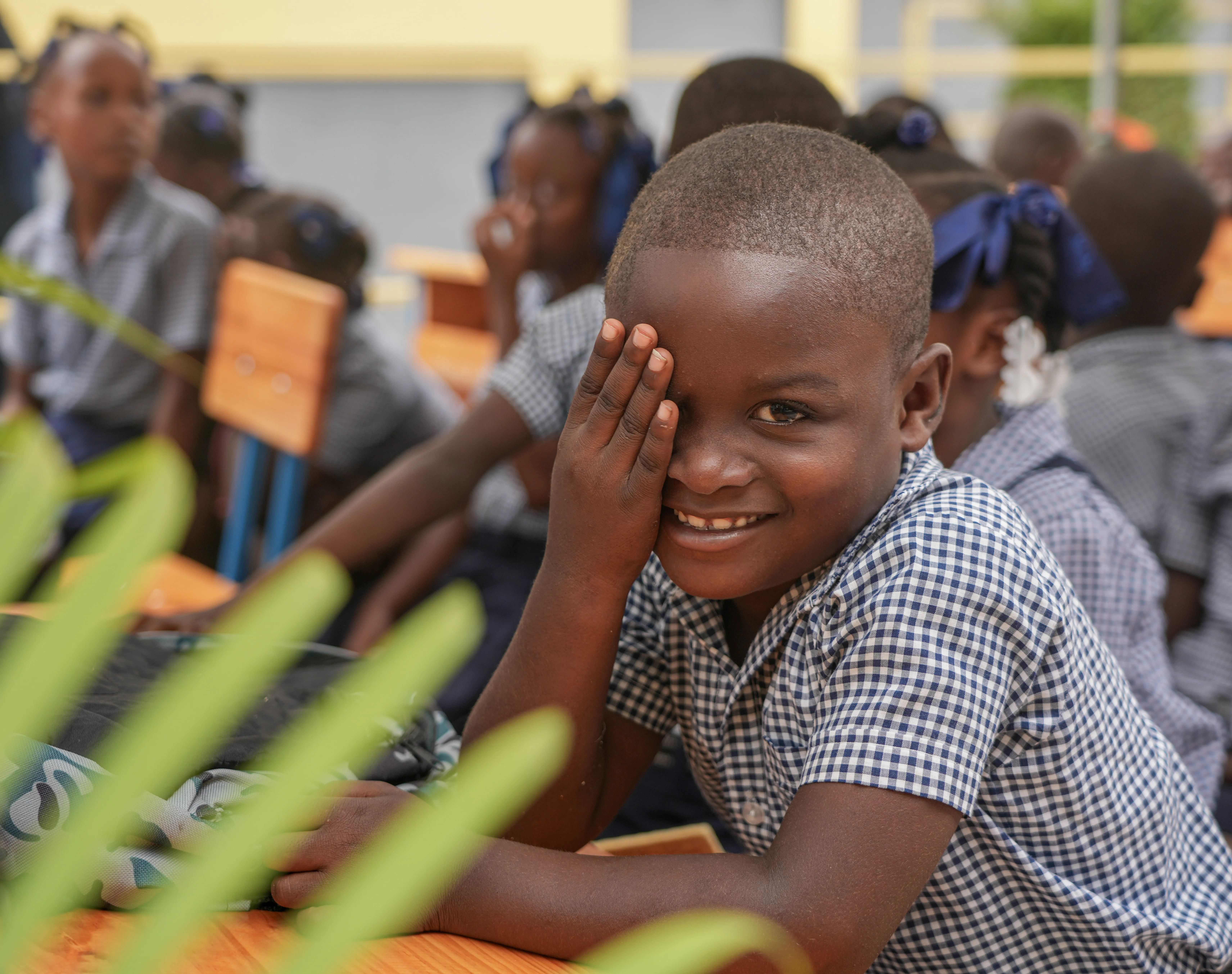 A young boy smiles during the inauguration ceremony of his school in Maingrette.