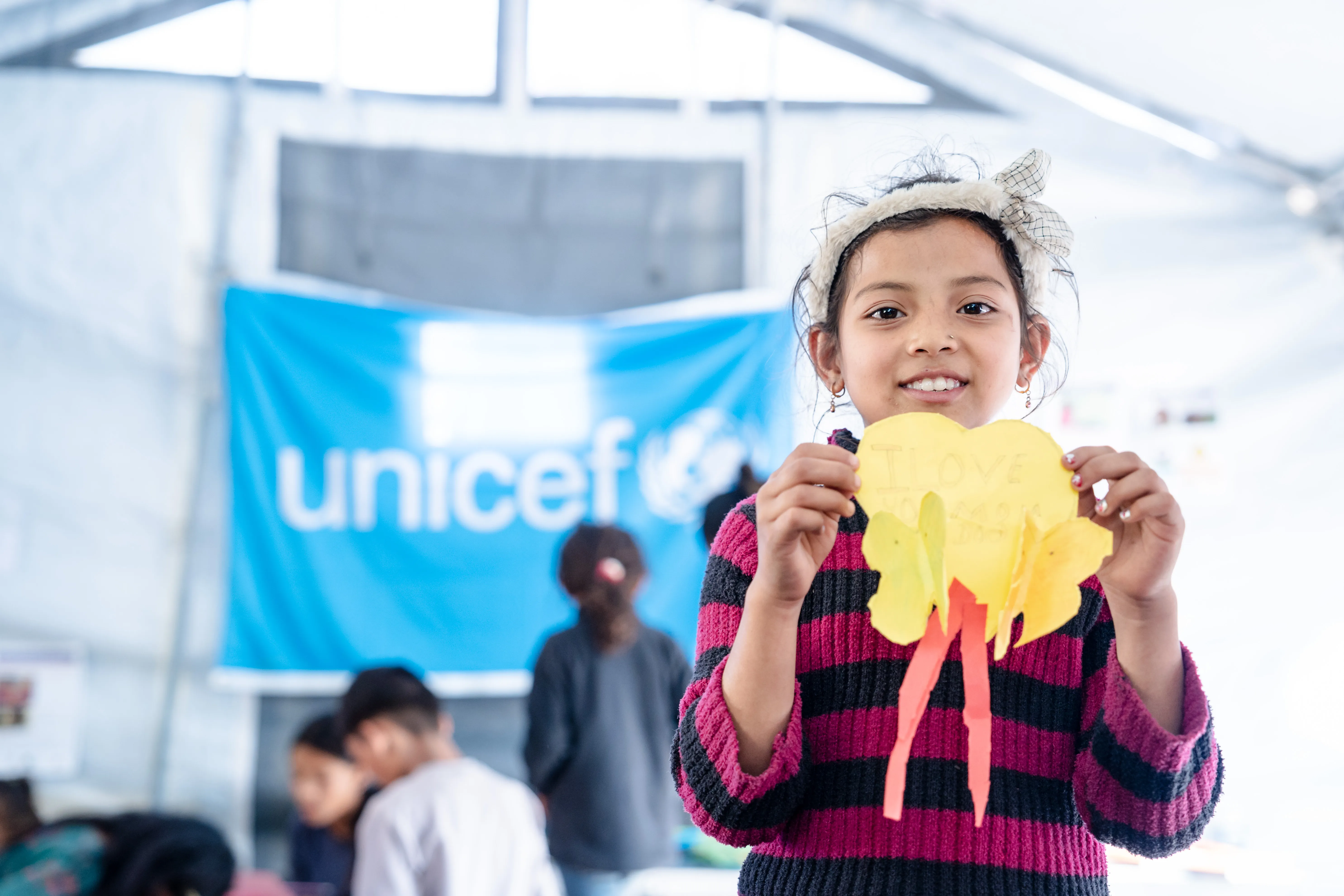 Girl holding a paper craft at a UNICEF child-friendly space set up after Nepal's earthquake.