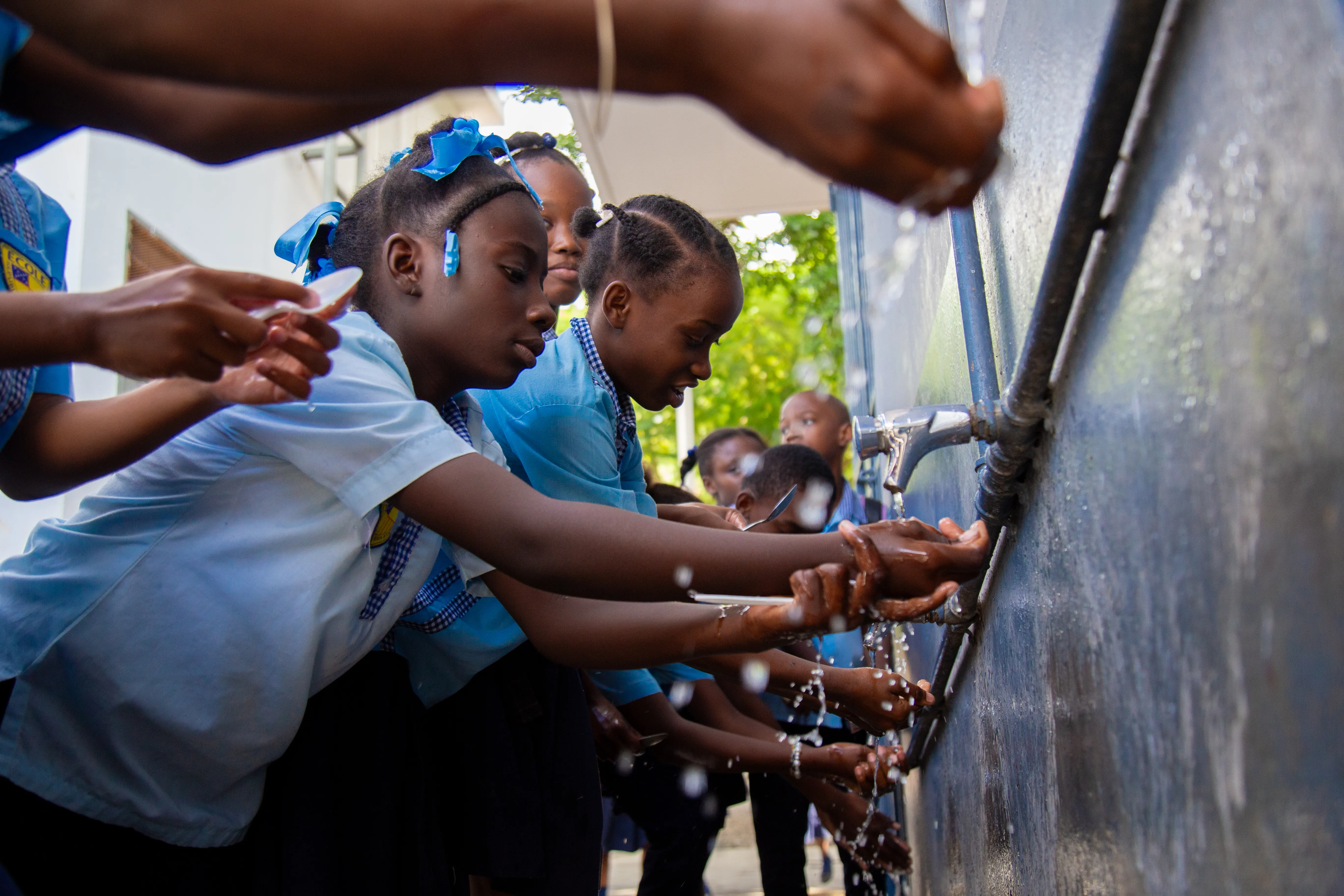 Students washing hands in the handwashing device built by UNICEF.