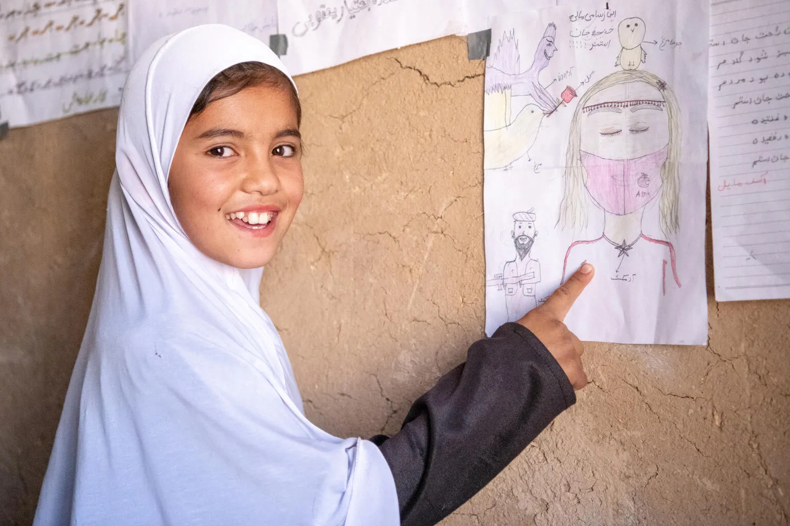 La jeune Khadija, âgée de neuf ans, montre l’un de ses dessins dans sa salle de classe communautaire soutenue par l’UNICEF dans le village de Bagh-e-Jalal de la province de Daikundi, au centre de l’Afghanistan.