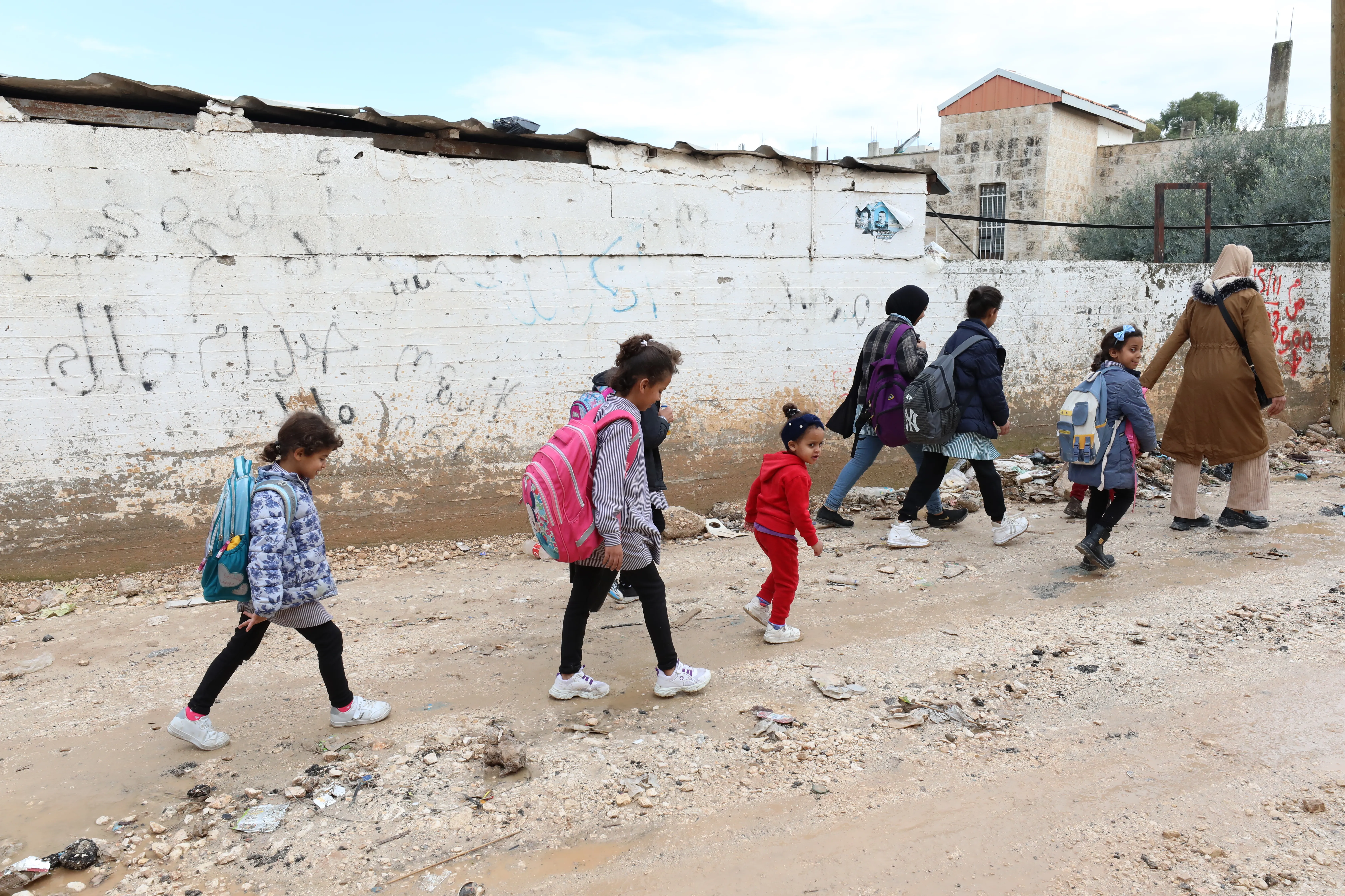 Des enfants retournent à l'école à pied au milieu des décombres dans les rues de Jénine, en Cisjordanie.