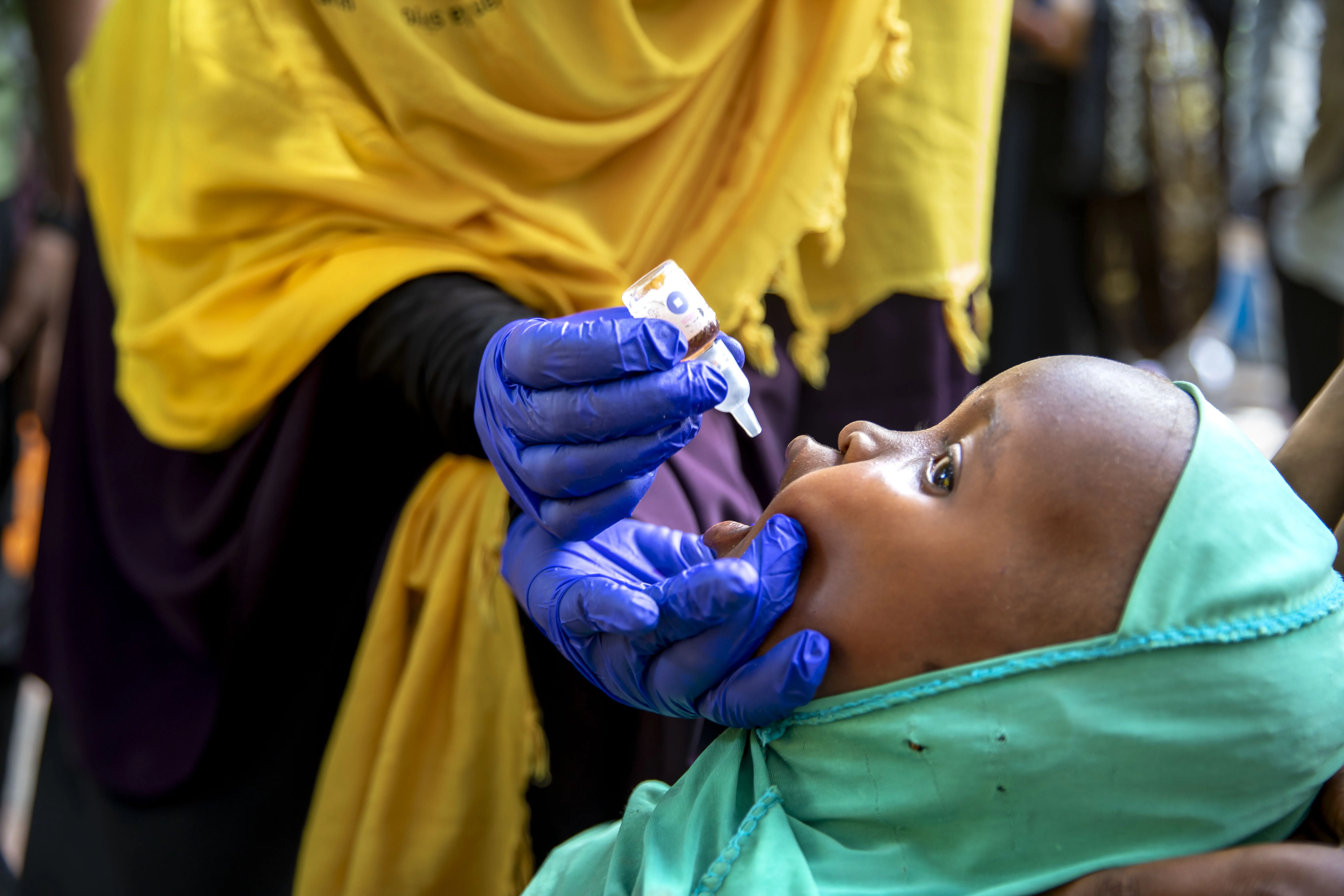 A child in Sudan is receiving a polio vaccination