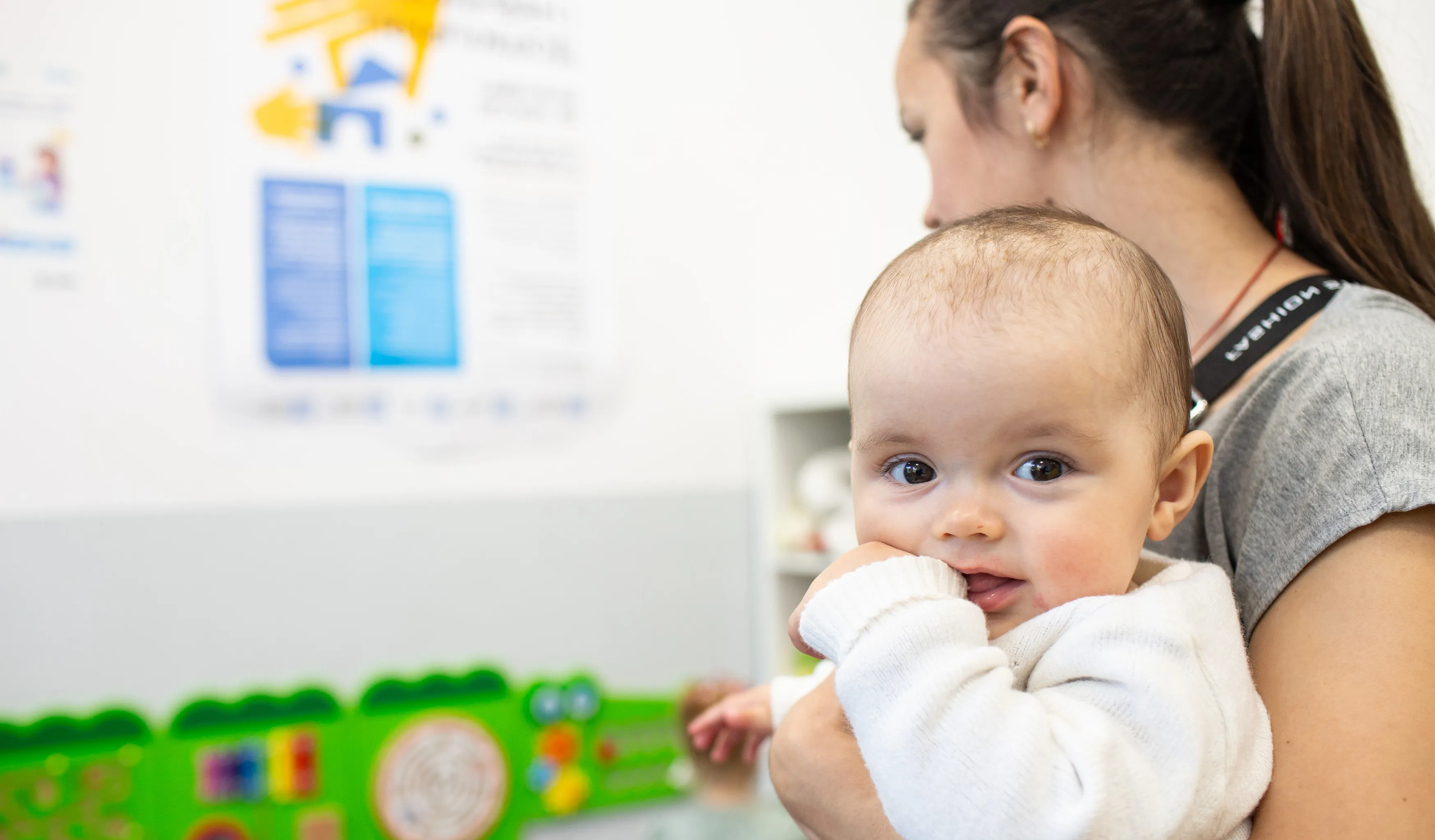 A mother lovingly holds her baby in a warmly lit room, showcasing a tender moment between them.