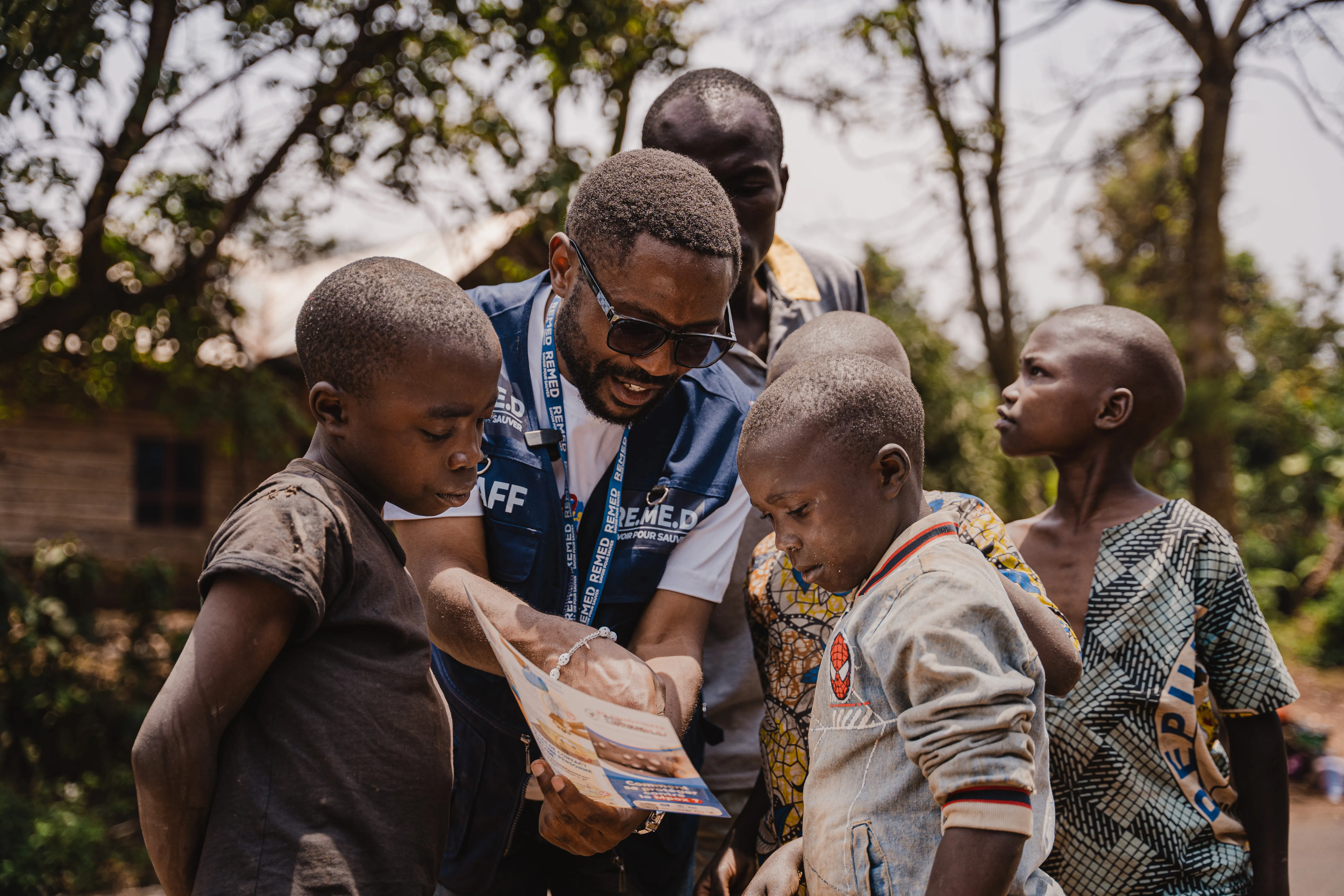 A health worker is seen educating children about mpox symptoms and prevention measures.