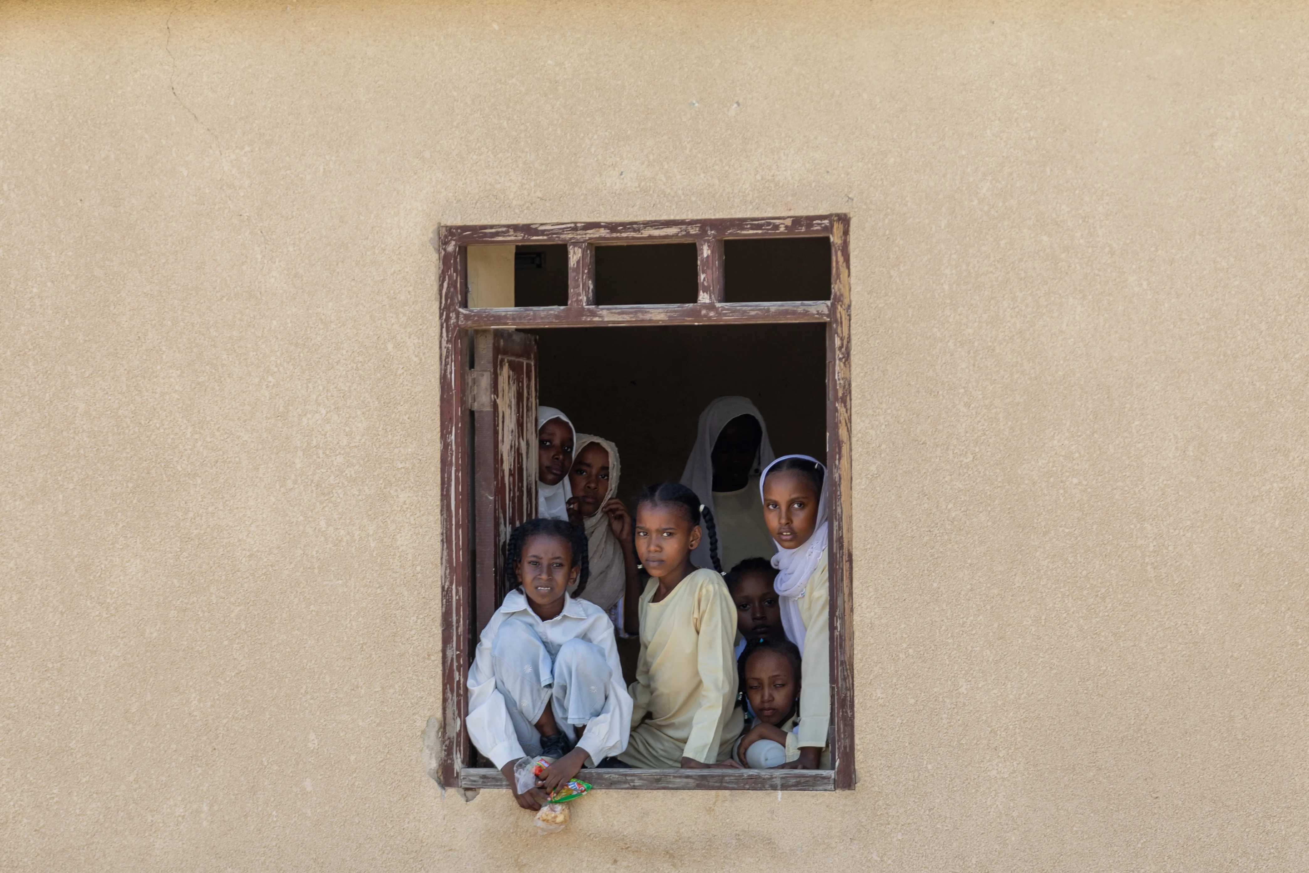 A group of children look out of the window of a school in Port Sudan.