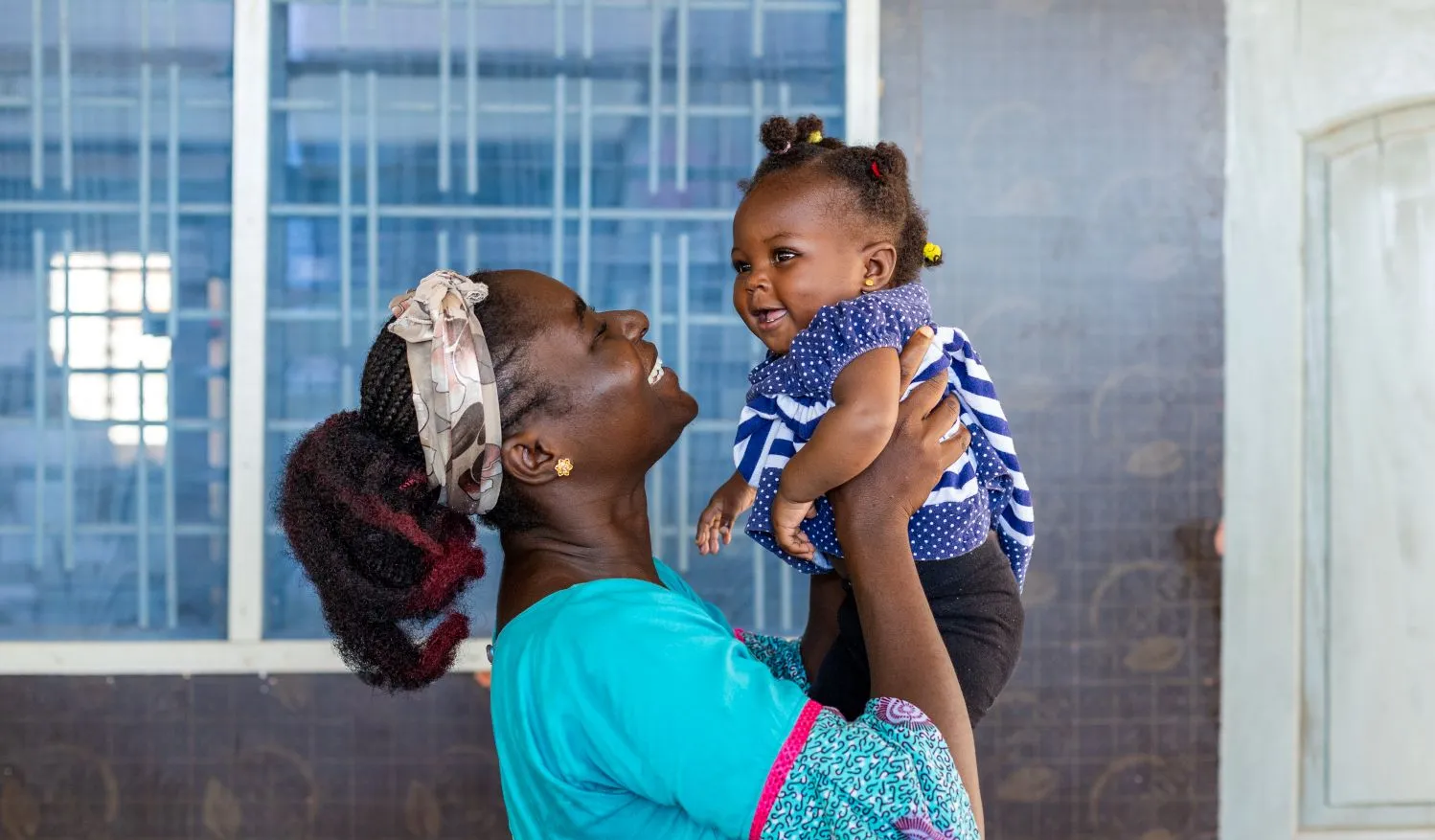 Une femme tient un bébé souriant.