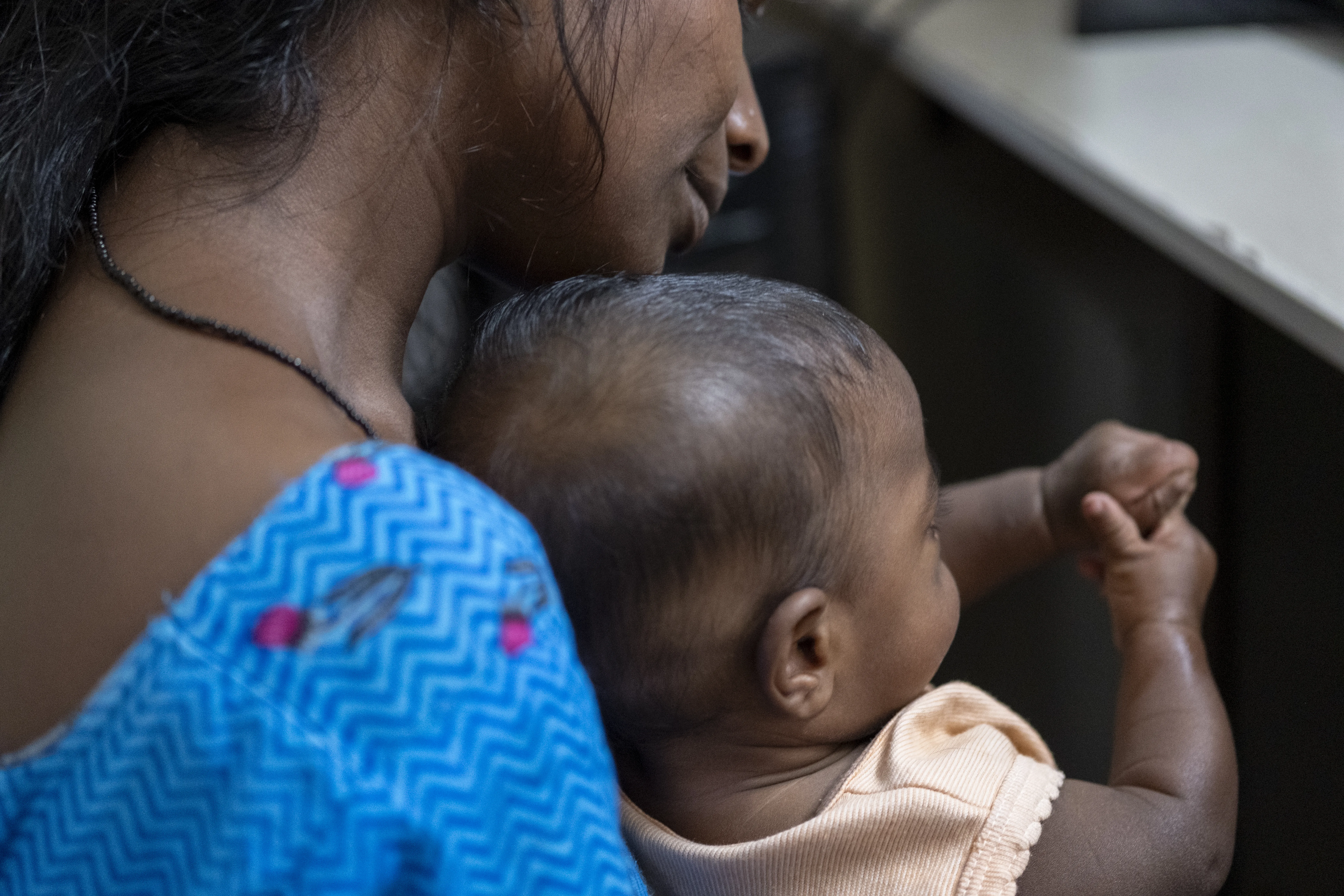 Mother living with HIV holds her baby at a testing centre