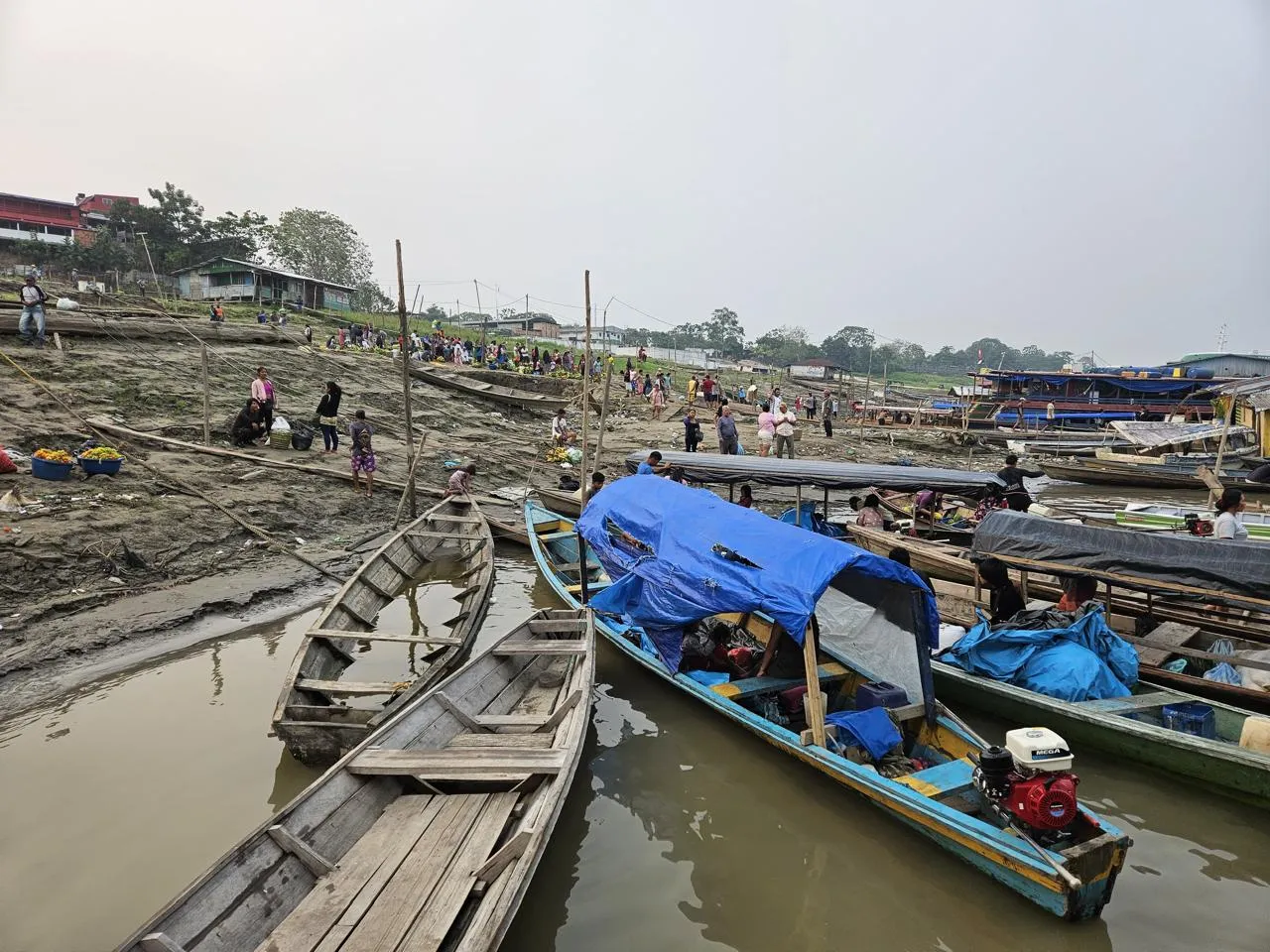 De petits bateaux de pêche semblent être échoués sur un rivage alors que les eaux de la crue se retirent. 