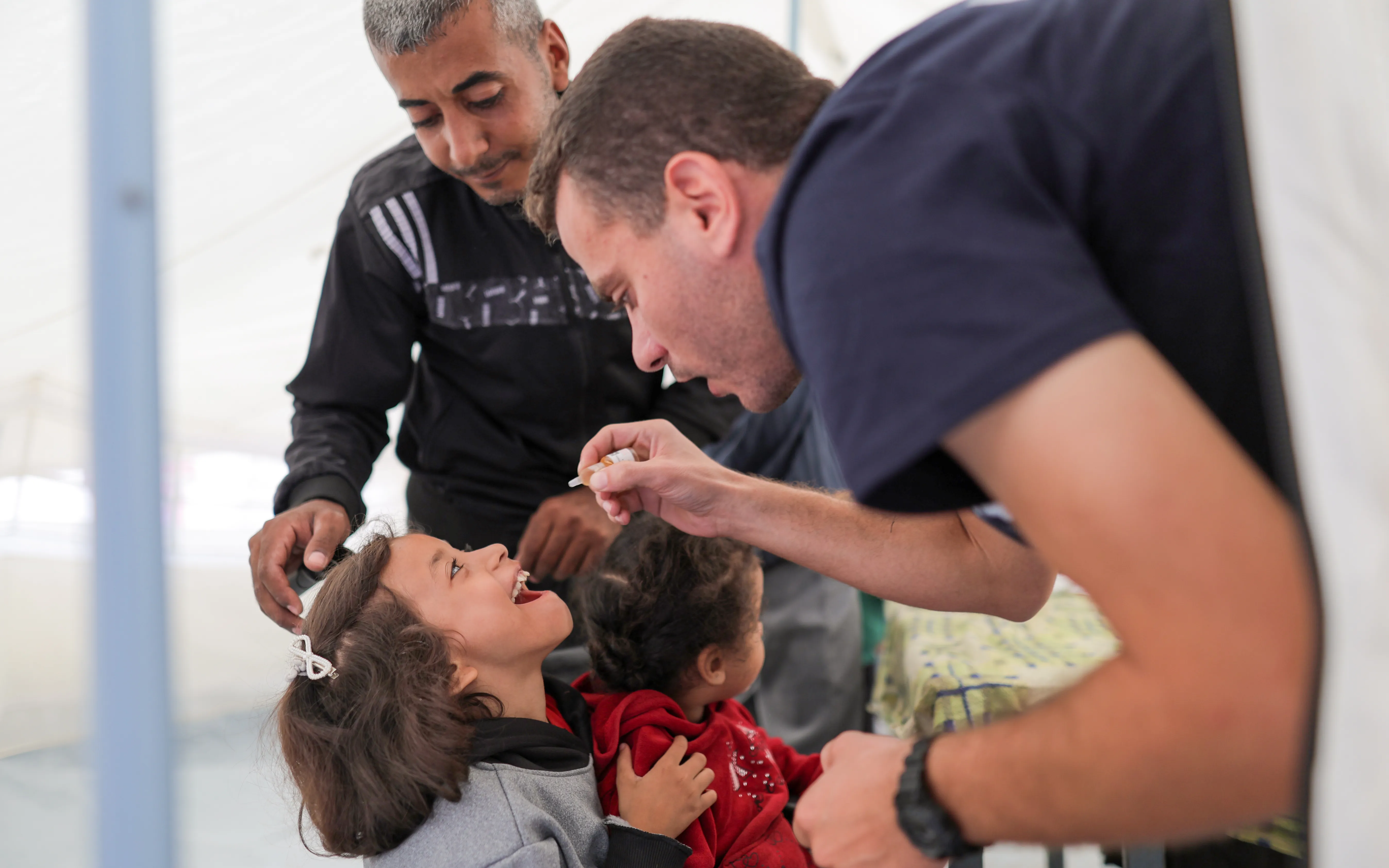 A health worker administers polio vaccine to a child in Gaza