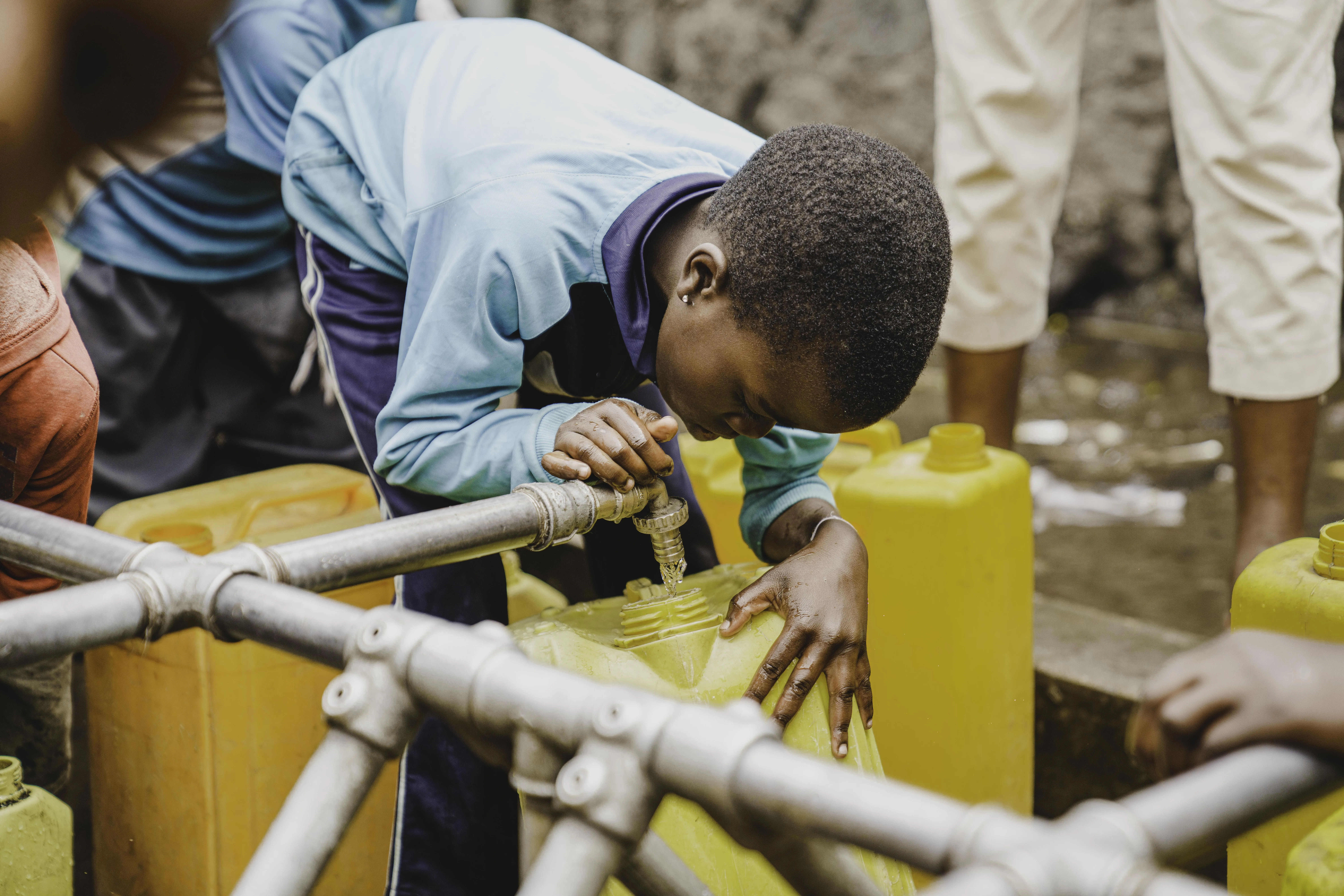 A child fills bucket with clean water in DR Congo
