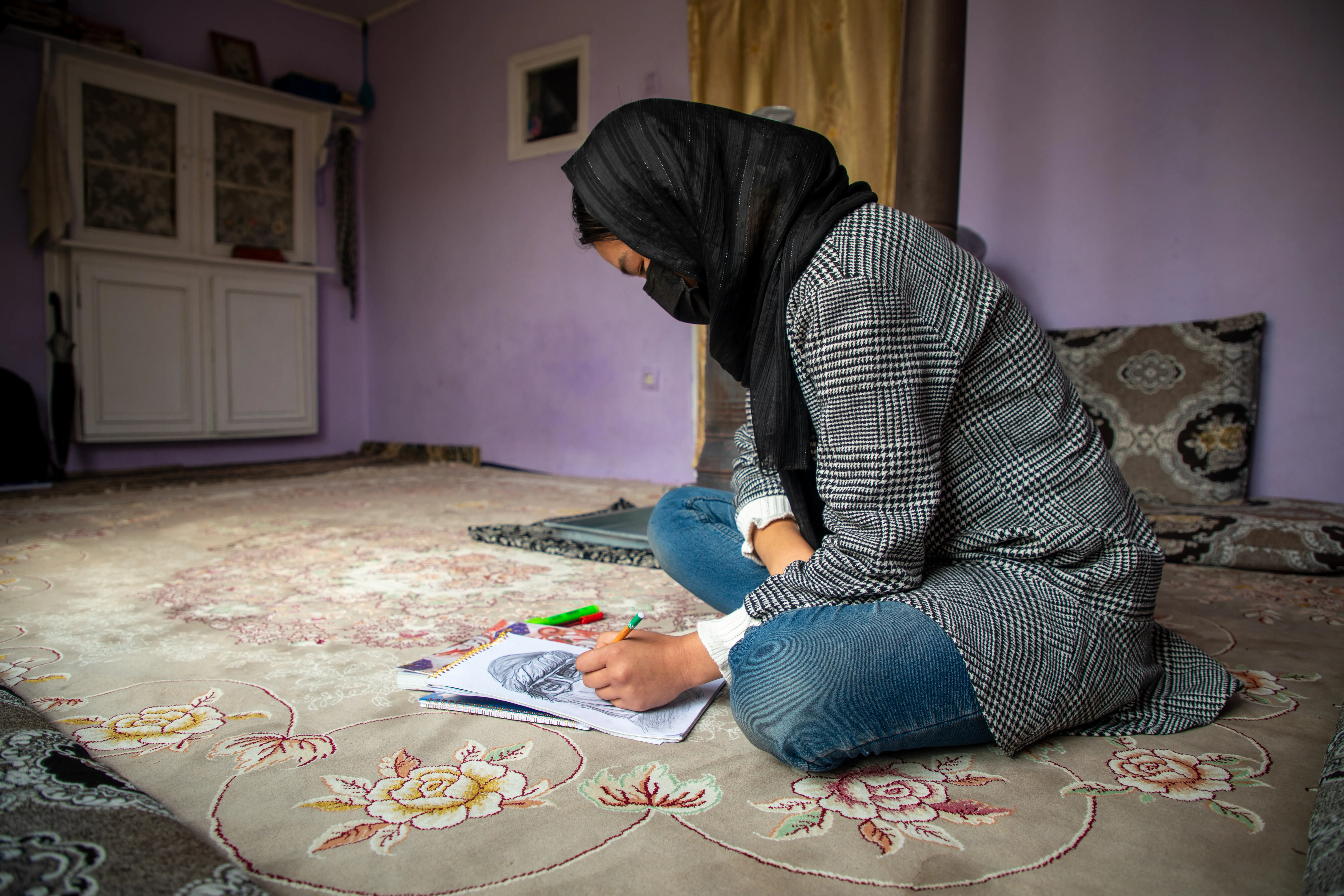 On February 10 2025, Ramzia*, 15, is drawing at home. She has been out of school for the past three and a half years. She was in eighth grade when girls were banned from school.