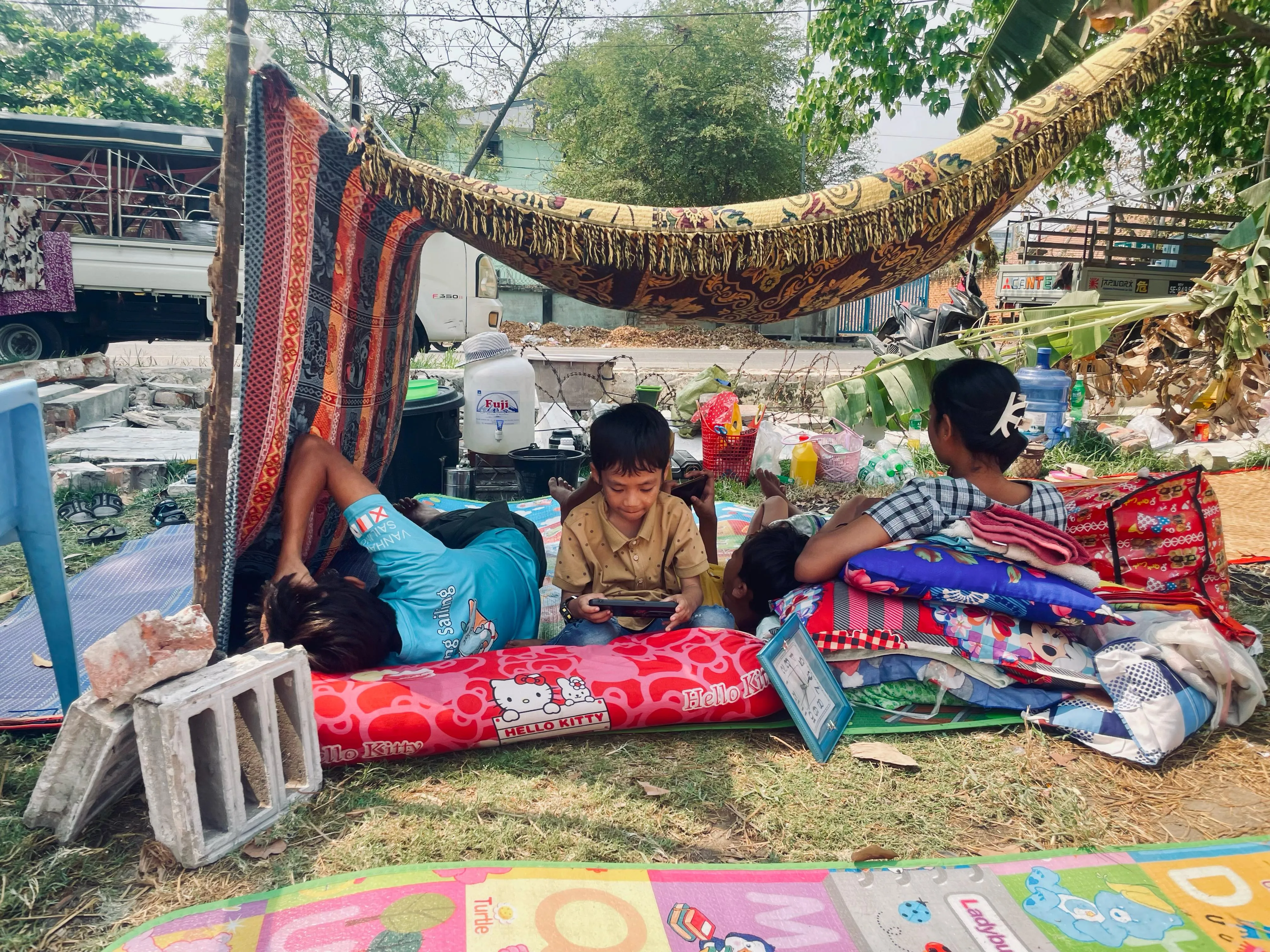 Children and families take shelter in makeshift outdoor spaces in Mandalay, Myanmar, following the devastating 7.7 magnitude earthquake that struck on 28 March 2025.