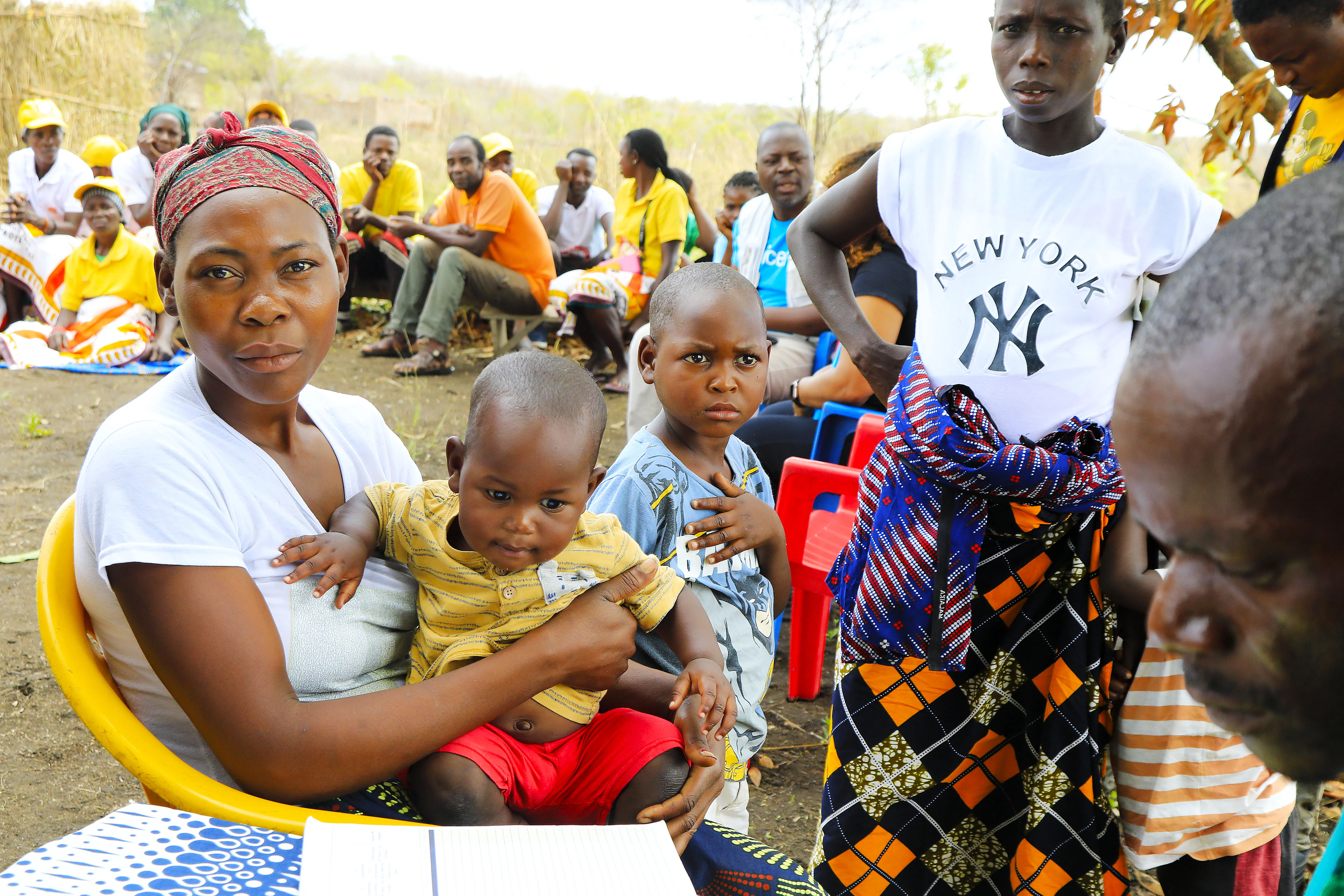 Mother holds her baby at a health centre with others gathered