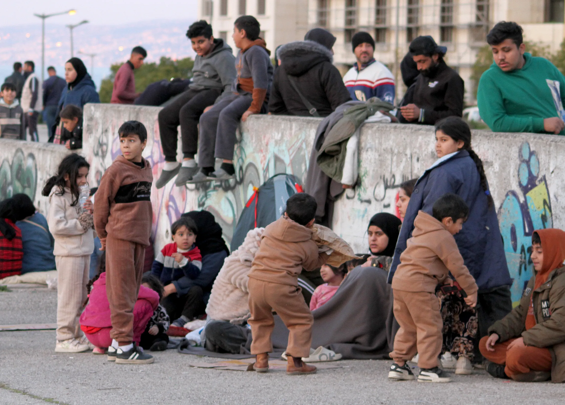 Displaced families gather in the streets to reach safety