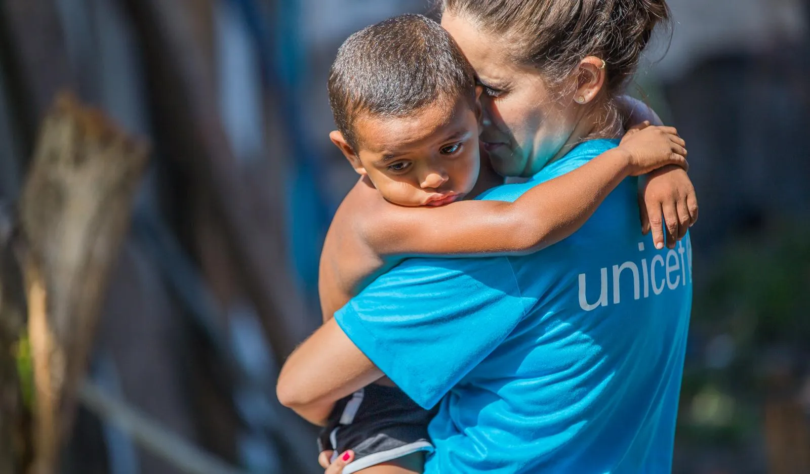 A UNICEF worker holds a toddler.