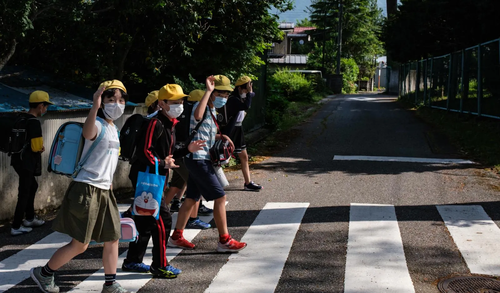 Children head to school in Japan, wearing masks to protect against COVID-19.