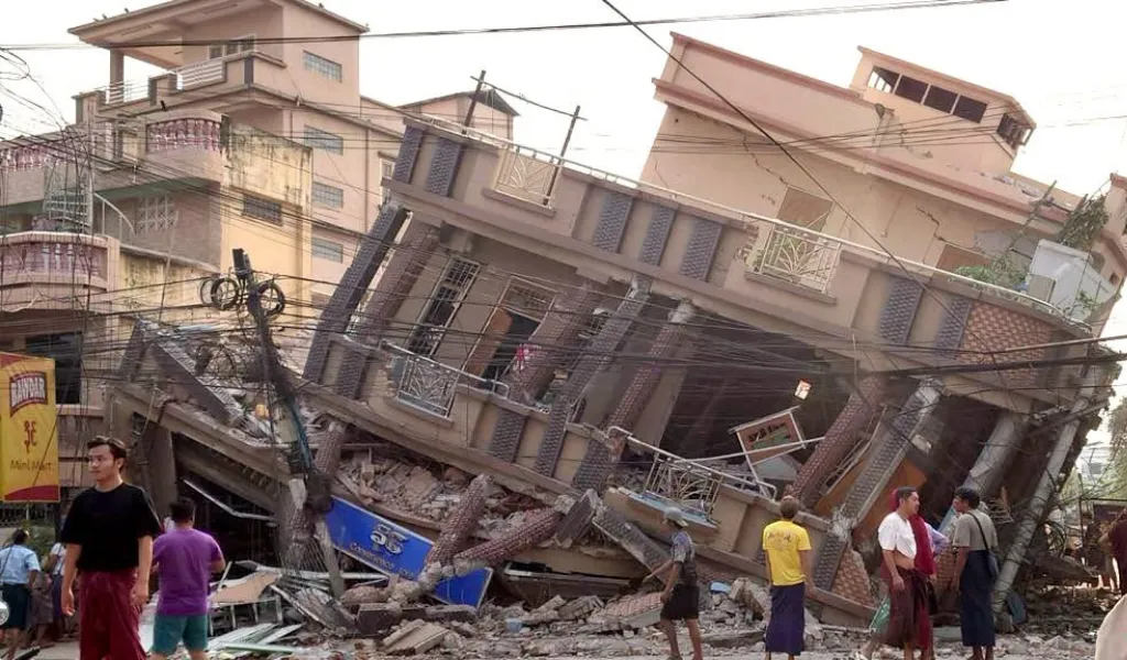 Un bâtiment au Myanmar gravement endommagé, avec des murs effondrés et des débris, à la suite d’un puissant tremblement de terre.