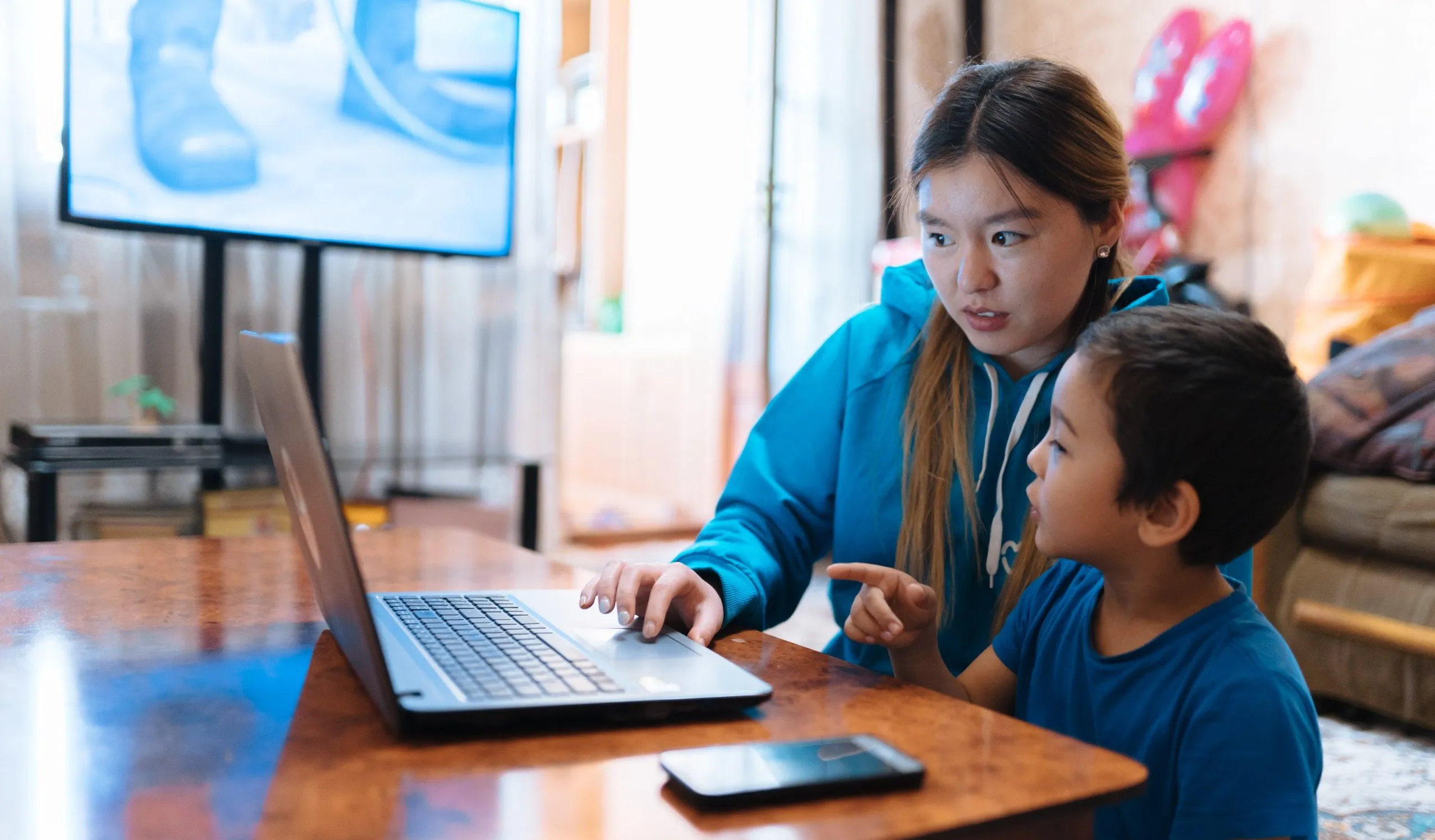 Aizaada, 21, a UNICEF Volunteer, transcribes lessons at home in Osh, Kyrgyzstan with her nephew, Aliyar.