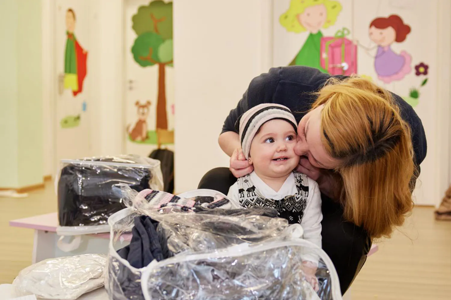 Mother putting on a warm cap on child's head