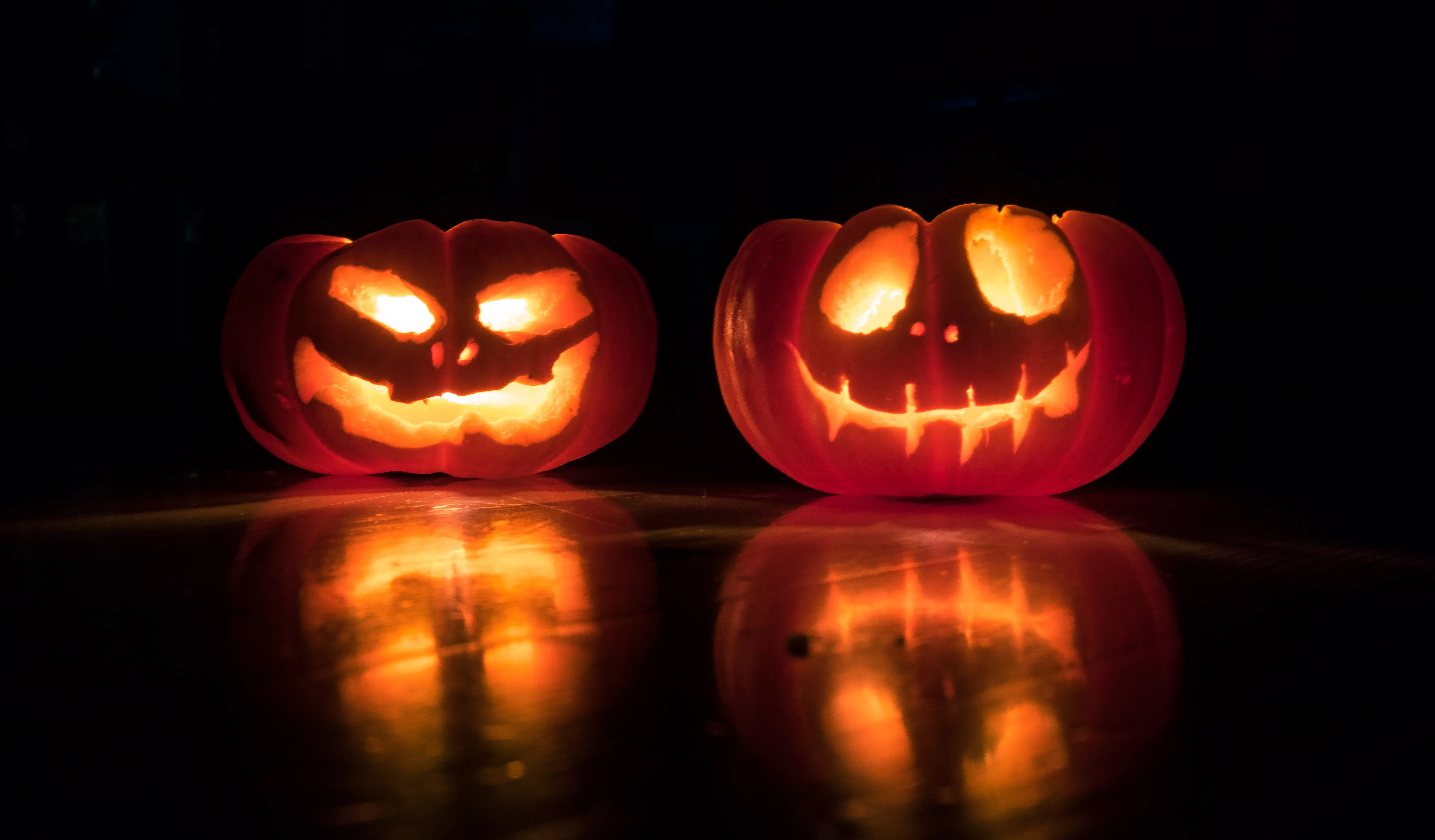 A pair of brightly lit jack o lanterns.
