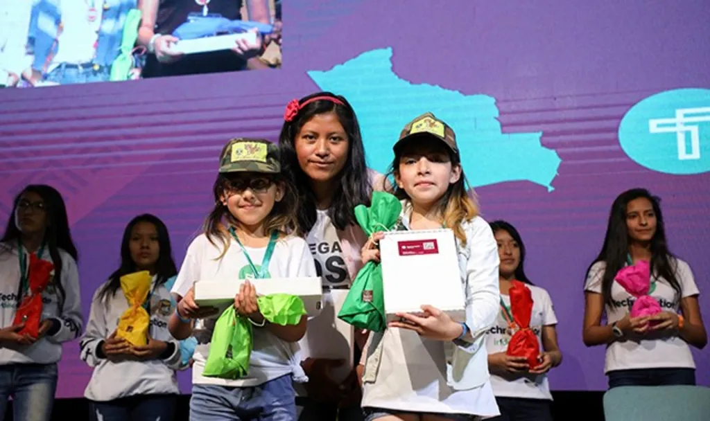 Girls receive awards at a tech event in Bolivia.