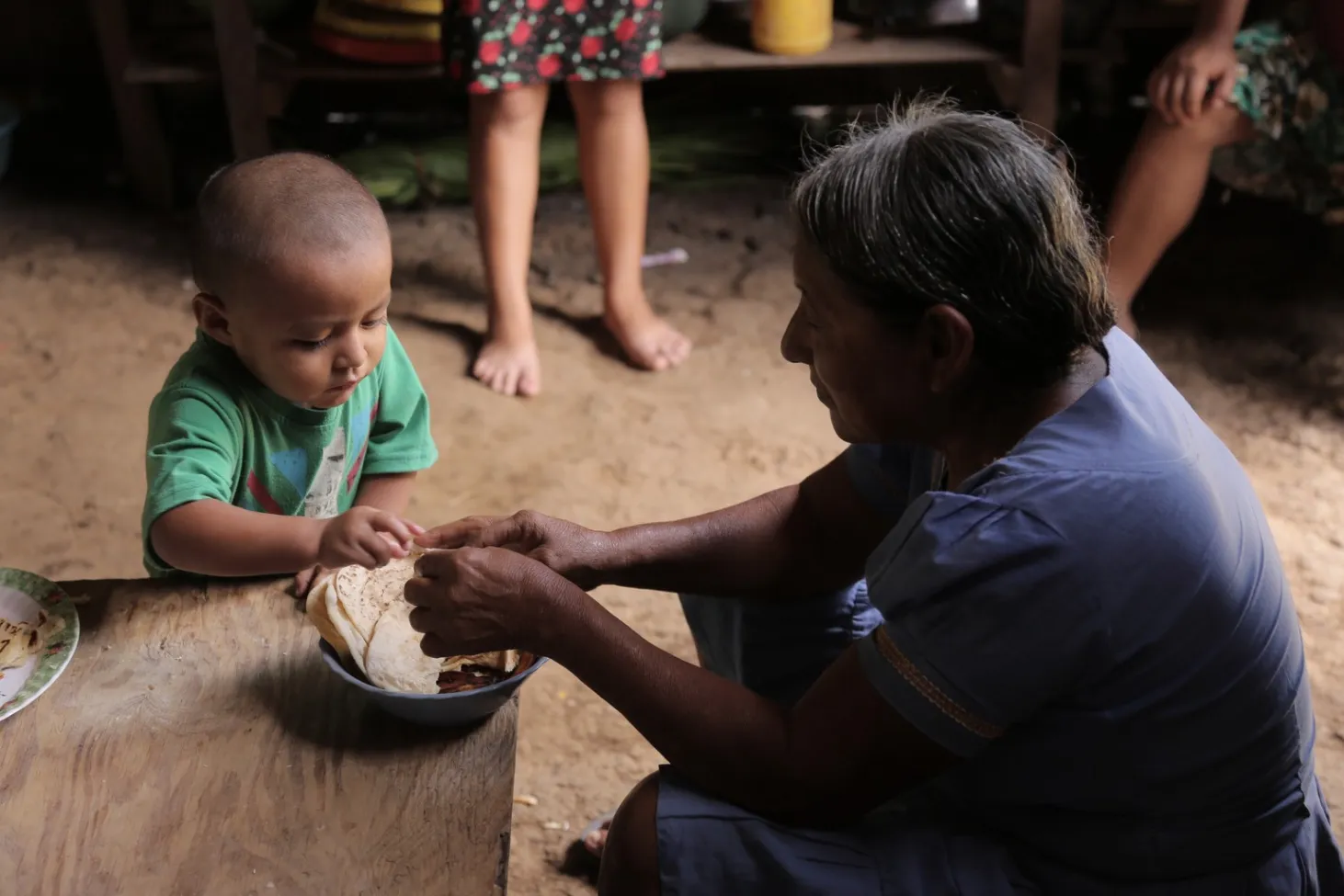 Abner helps his grandmother make tortillas at home. 