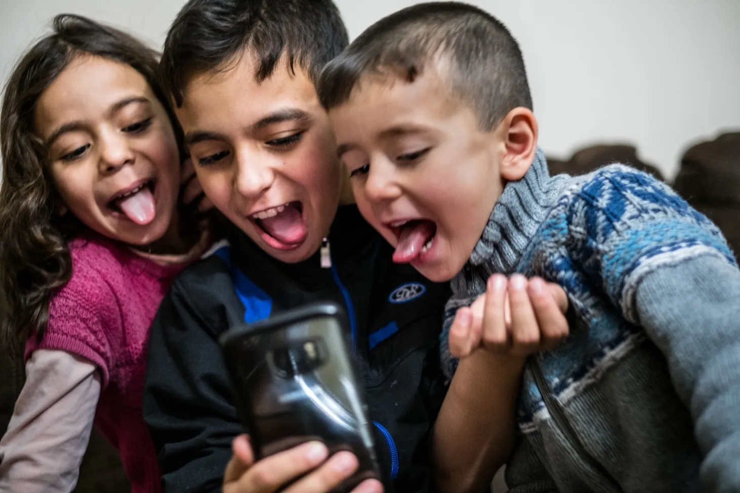 (Left-right) Shatha, Basel and Idress ‘morph’ funny faces they make and selfies they take using the phone’s camera.