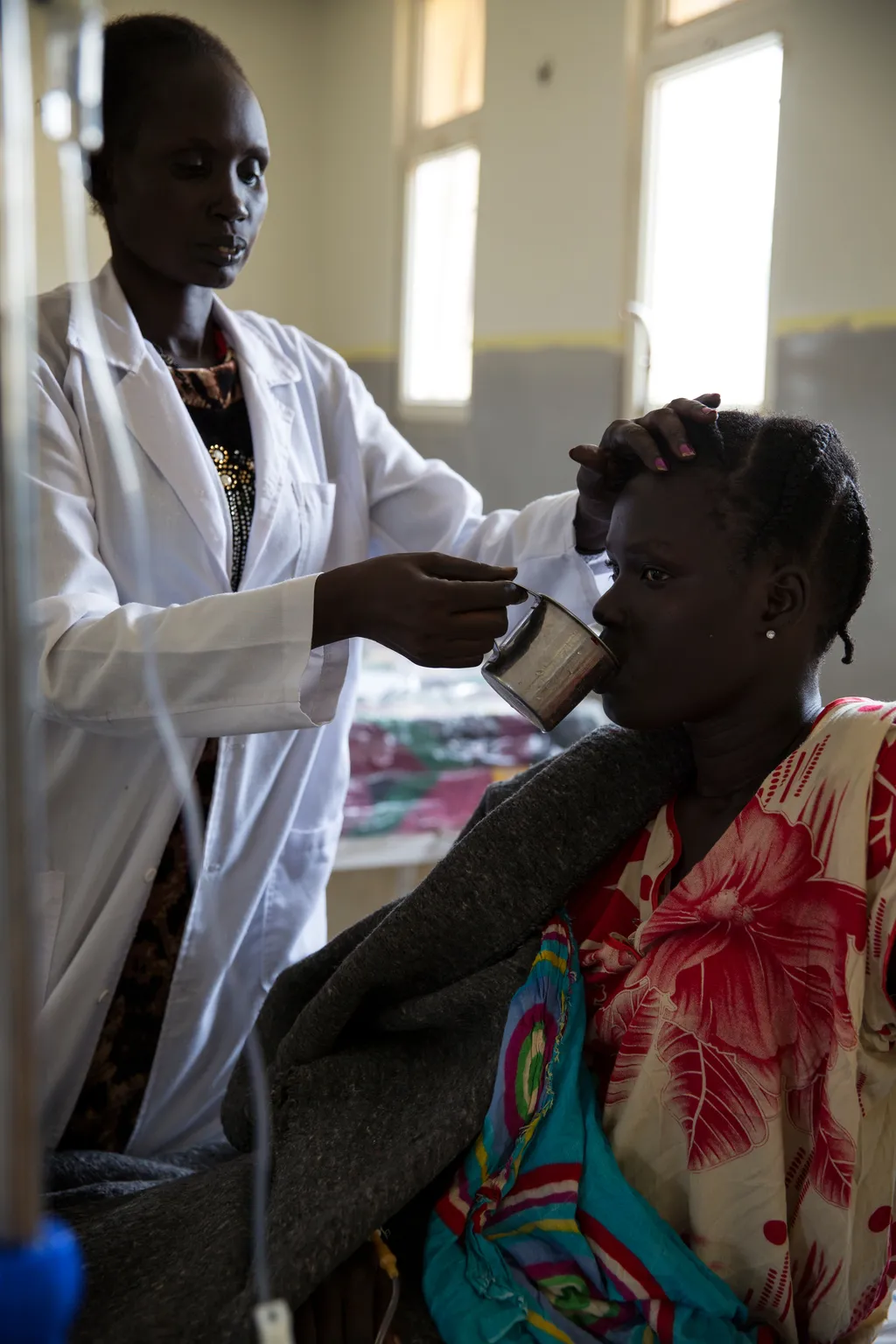 un médecin donne de l’eau potable à un patient