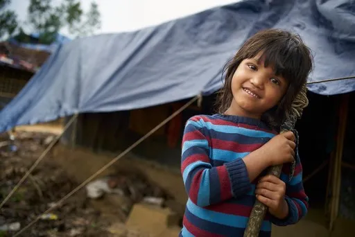 une fille sourit dans un camp des réfugiés au Bangladesh.