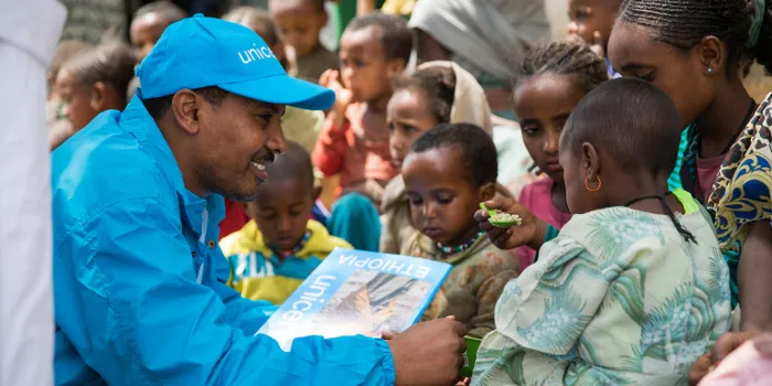 unicef staff helping children