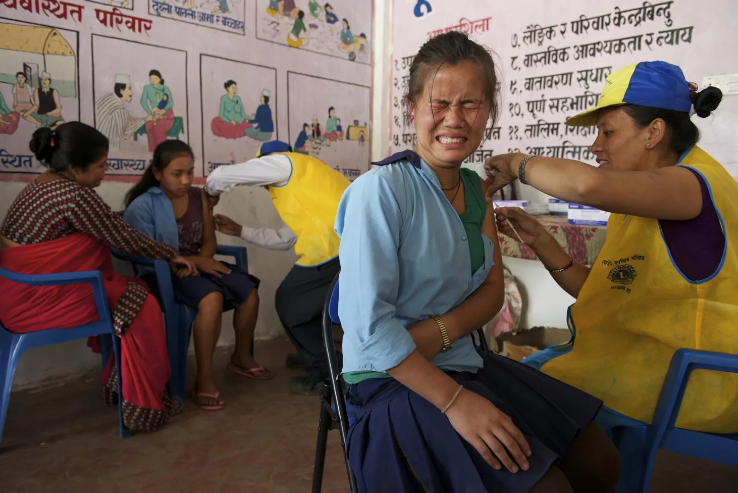 A schoolgirl is administered a measles-rubella vaccine at an immunization site in Ghermu Village.