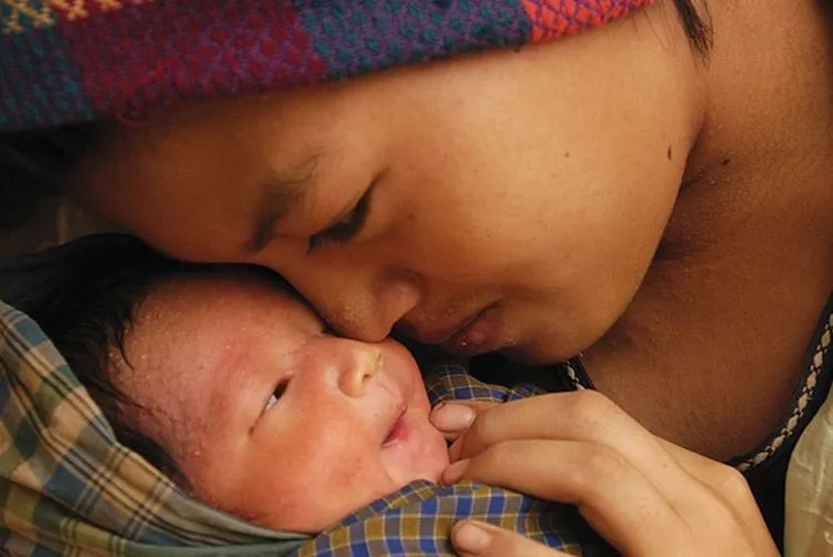 A mother cradles her newborn baby.