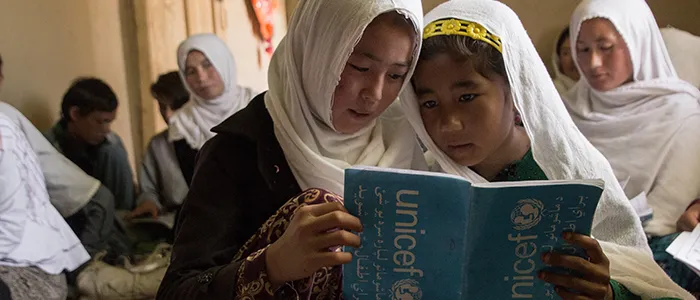 Deux filles lisent leurs notes de cours dans le centre d’apprentissage accéléré du village de Sharak e Muhajireen, dans le district de Nili de la province afghane de Darikundi. (2018)