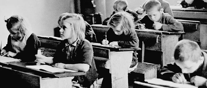 Des filles et des garçons suivent des cours de rattrapage dans une école d’urgence, qui se trouve dans la ville de Slezska Ostrava. (Tchécoslovaquie, 1946)