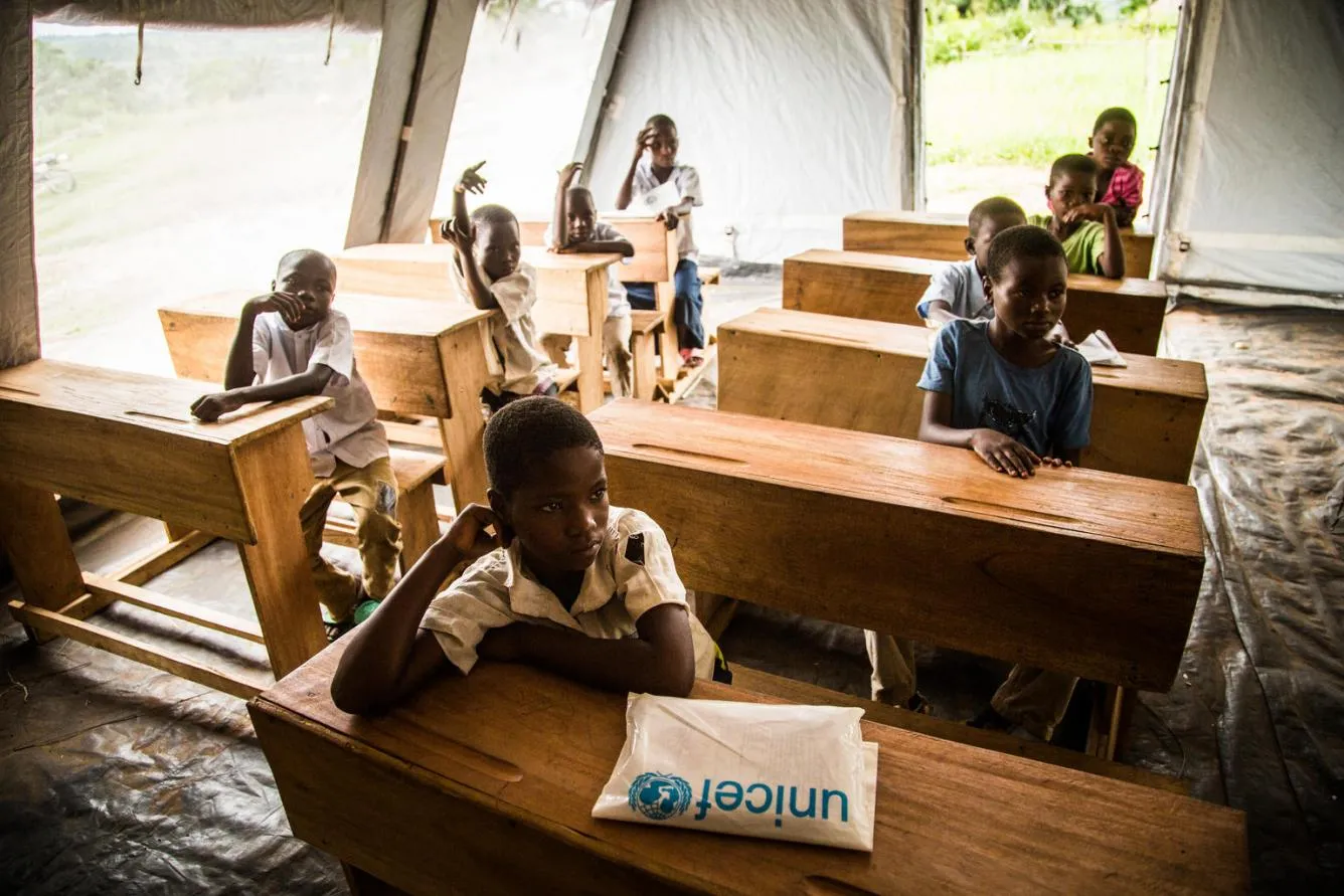 Des enfants assis dans un centre d’apprentissage temporaire en RDC